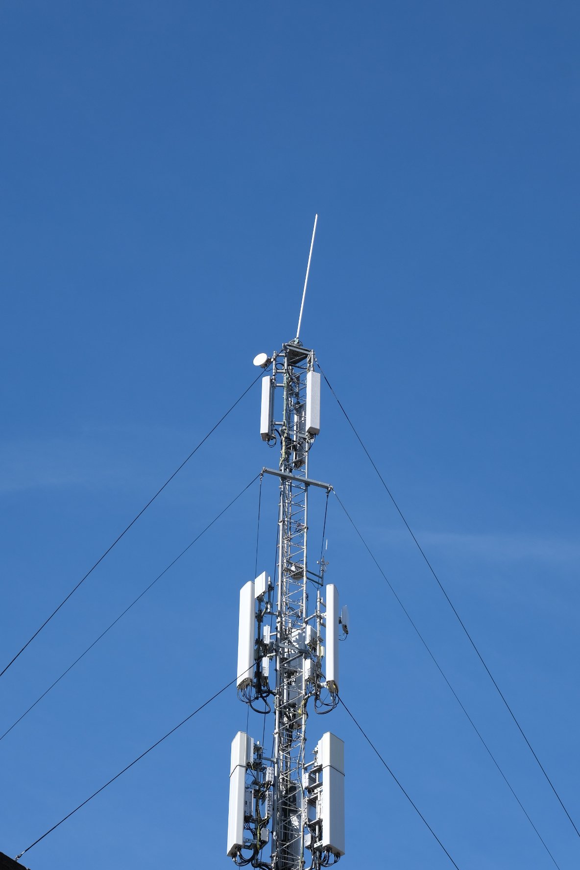 Een telecommunicatietoren tegen een heldere blauwe hemel.