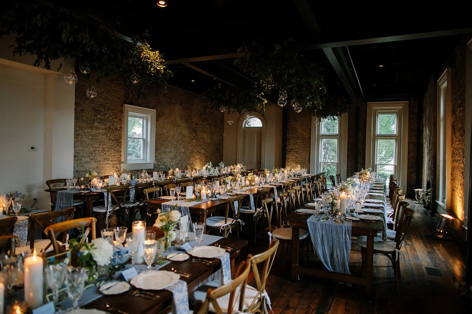 Elegant wedding reception setup in a historic event venue in downtown Nashville with long tables, candles, floral arrangements, and ambient lighting.