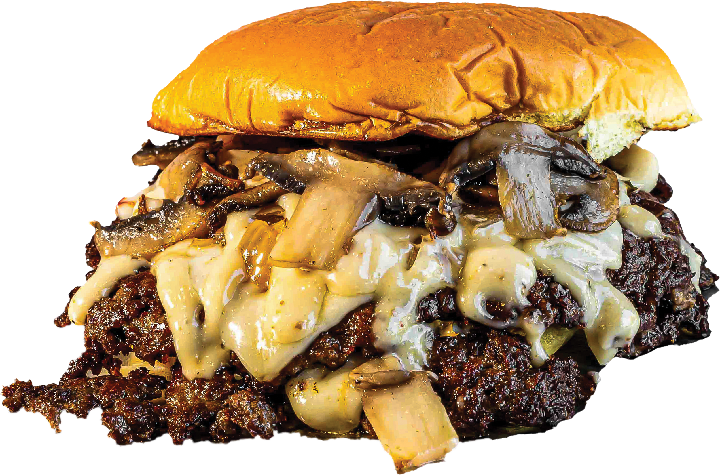 Close-up of a cheeseburger with cheese, grilled onions, and sautéed mushrooms on a beef patty, topped with a toasted bun.