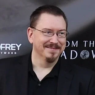 Portrait of Michael Kuciak, a man with glasses and a goatee, attending a film premiere.