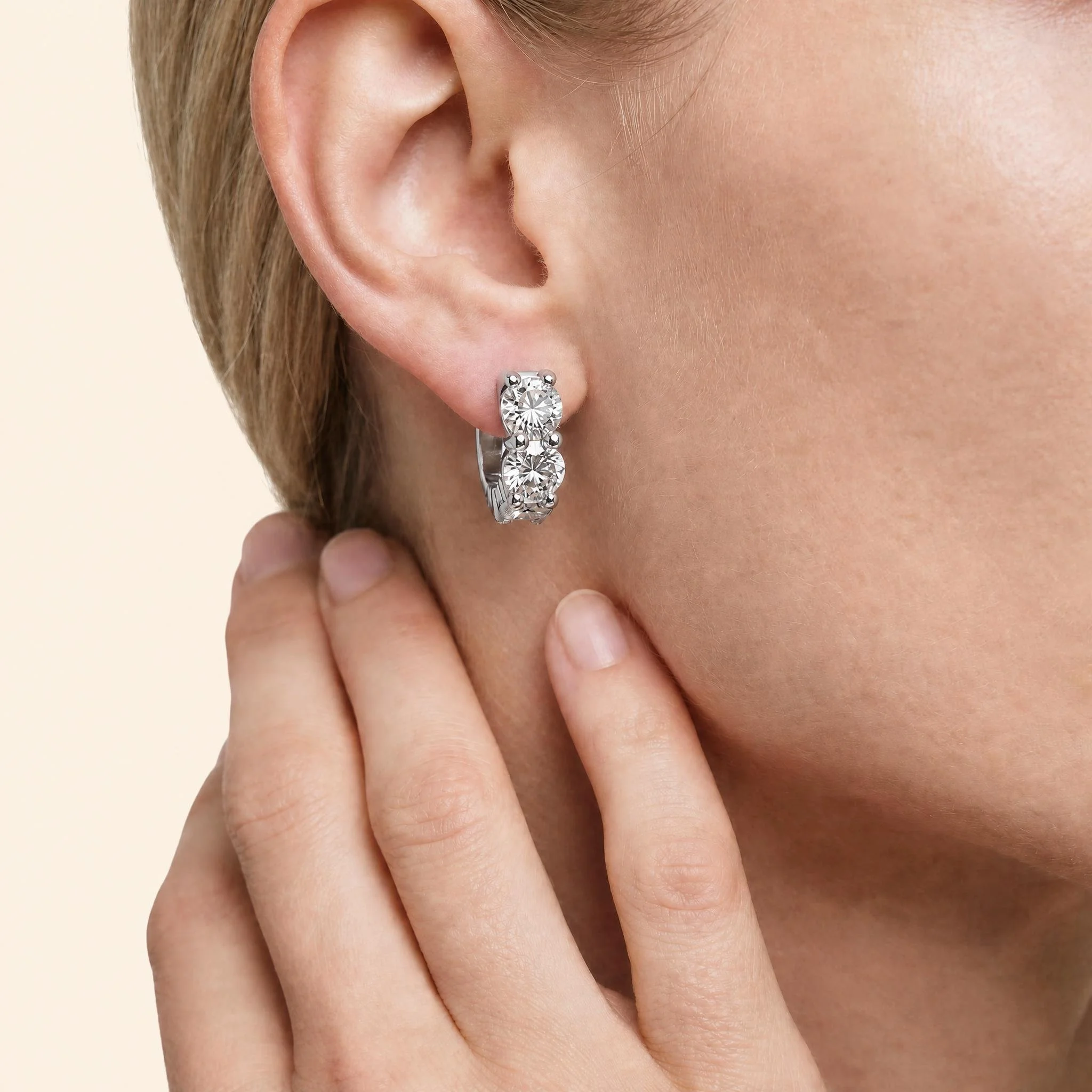 trio diamond huggie earrings white gold on model.jpeg