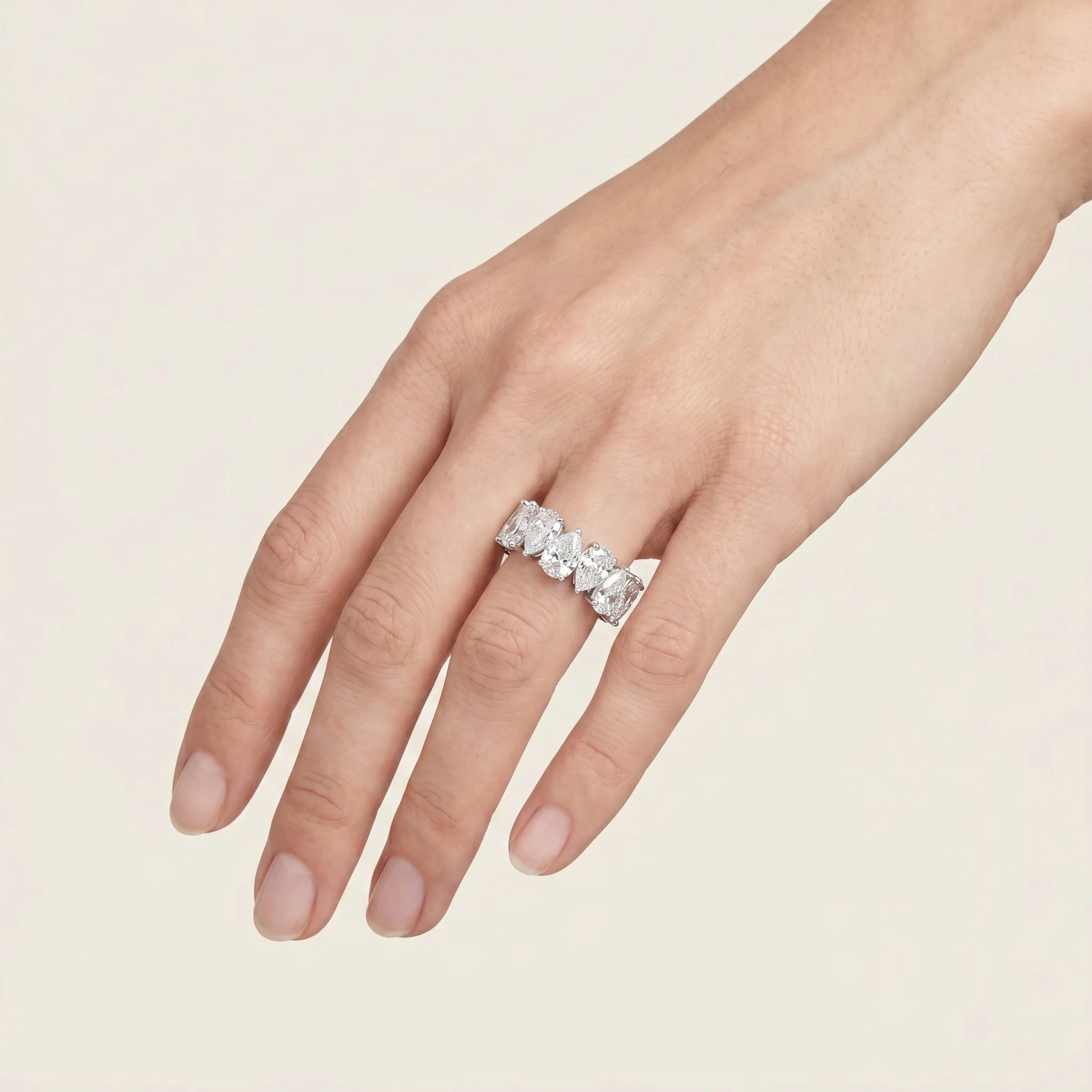 Close-up of a person's hand wearing a silver ring with multiple rectangular diamonds.