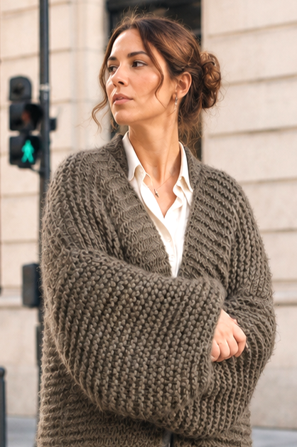 Model wearing a fluffy, oversized green wool cardigan with drop shoulders, slouchy balloon sleeves, and ribbed textured pattern over a white collared shirt.
