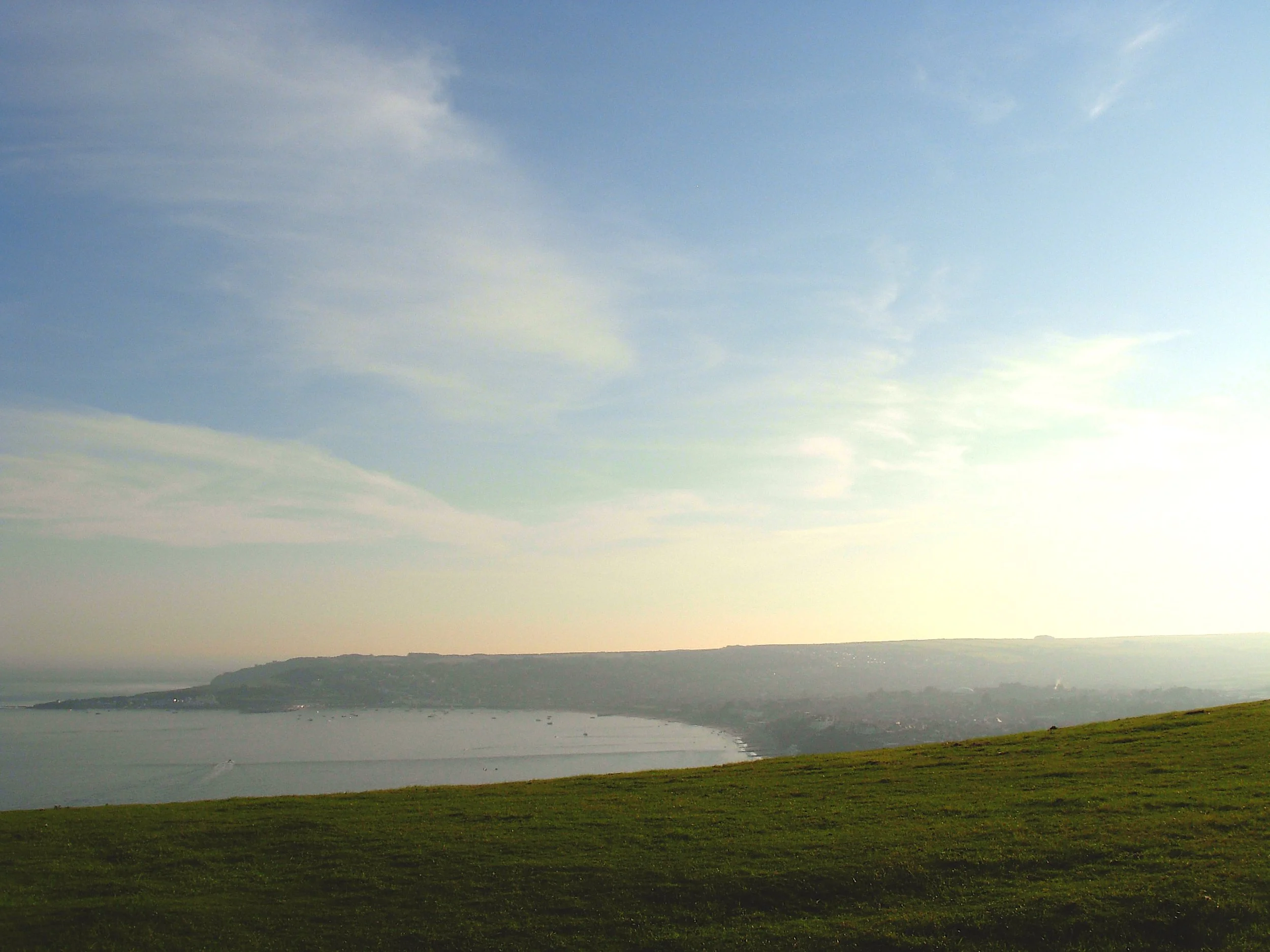 A clear landscpe of sky, field and sea