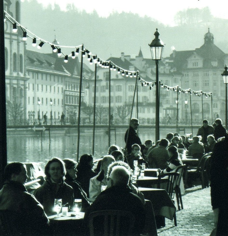 People enjoying eachother's company at a city riverside café.