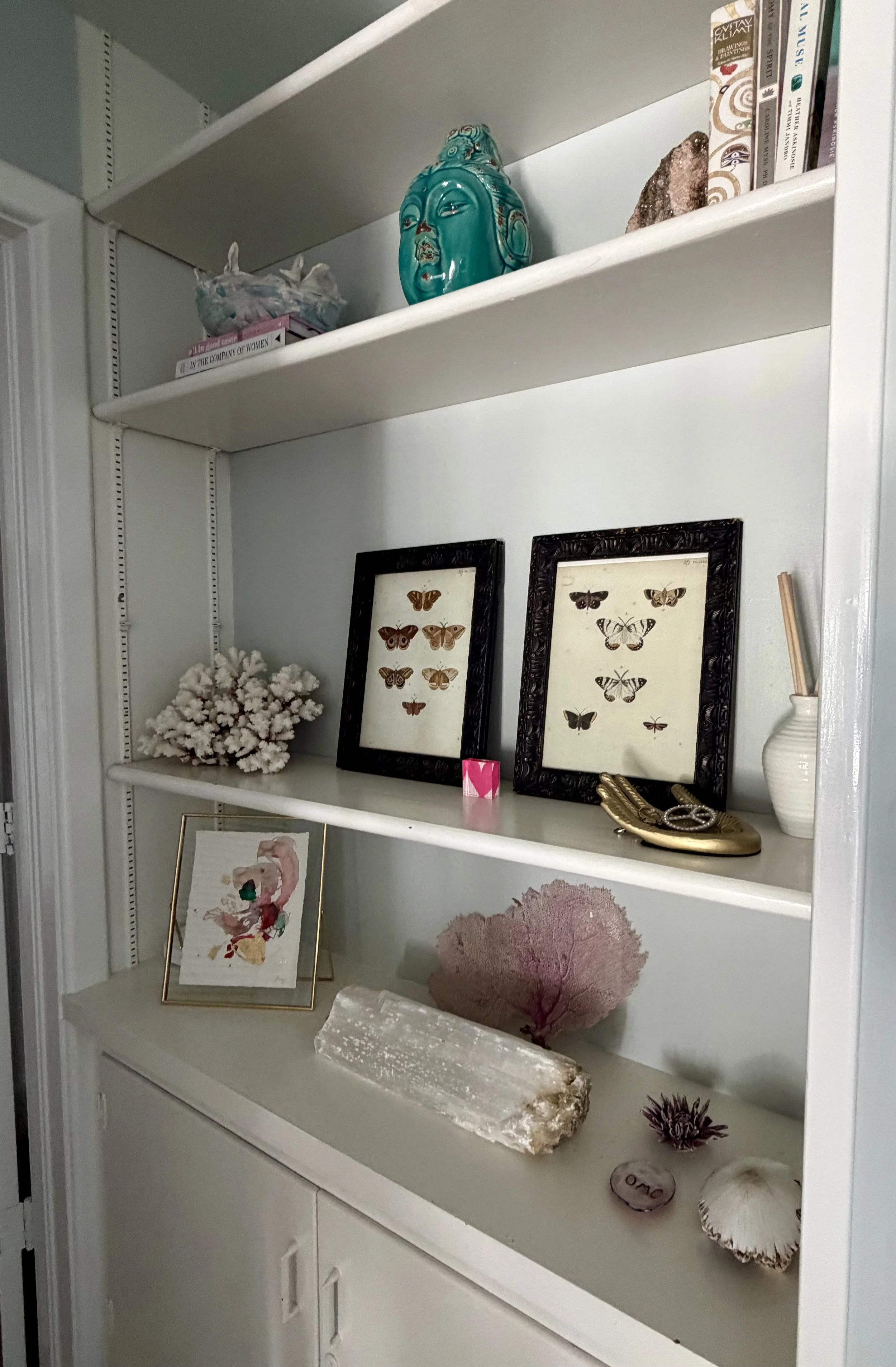crystals and buddha on shelf