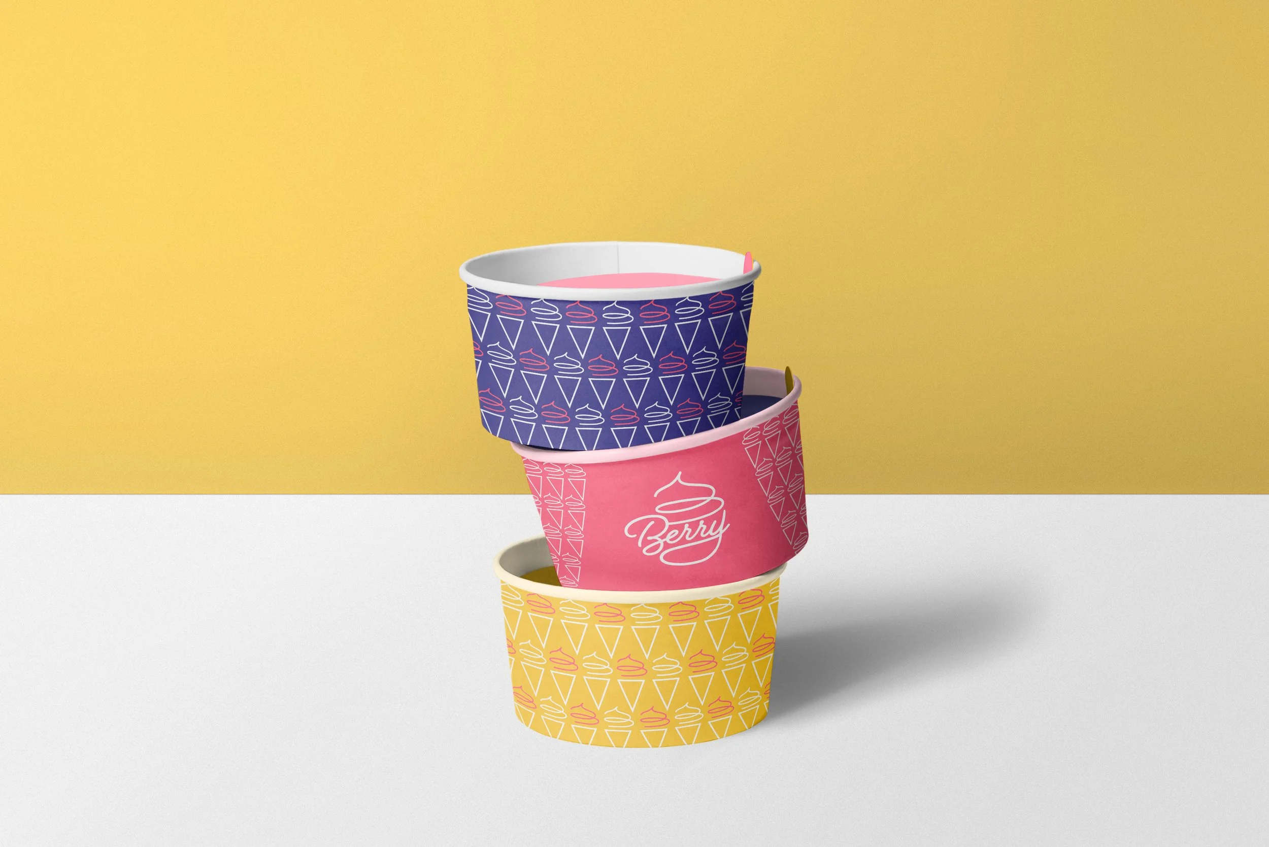Stack of three colorful ice cream containers with patterns and the word "Berry" on the middle container, against a yellow and white background.