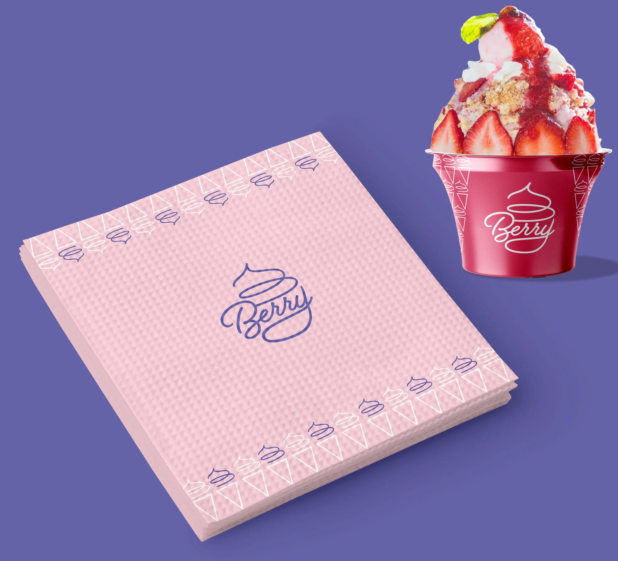 A stack of pink paper napkins with blue and white designs and the word "Berry" on top, alongside a red cup filled with strawberry ice cream topped with strawberry sauce, whipped cream, and a mint leaf, set on a purple background.