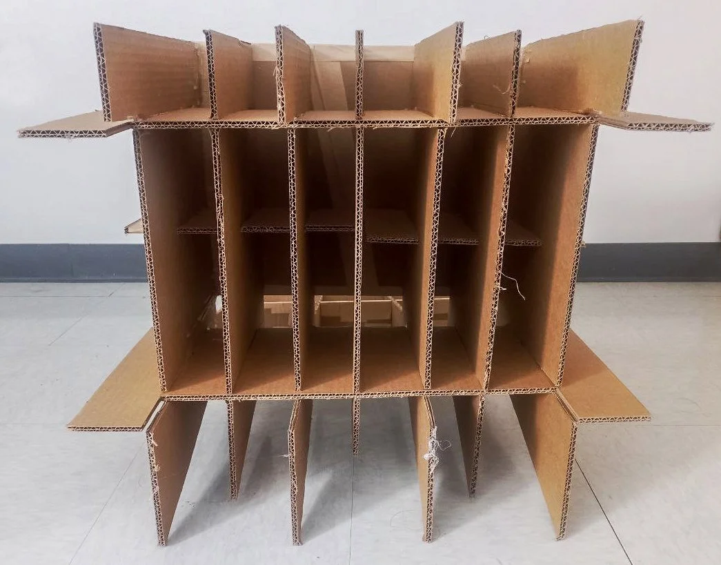 Cardboard display stand with multiple compartments and fold-out sides, possibly for retail or exhibition use.