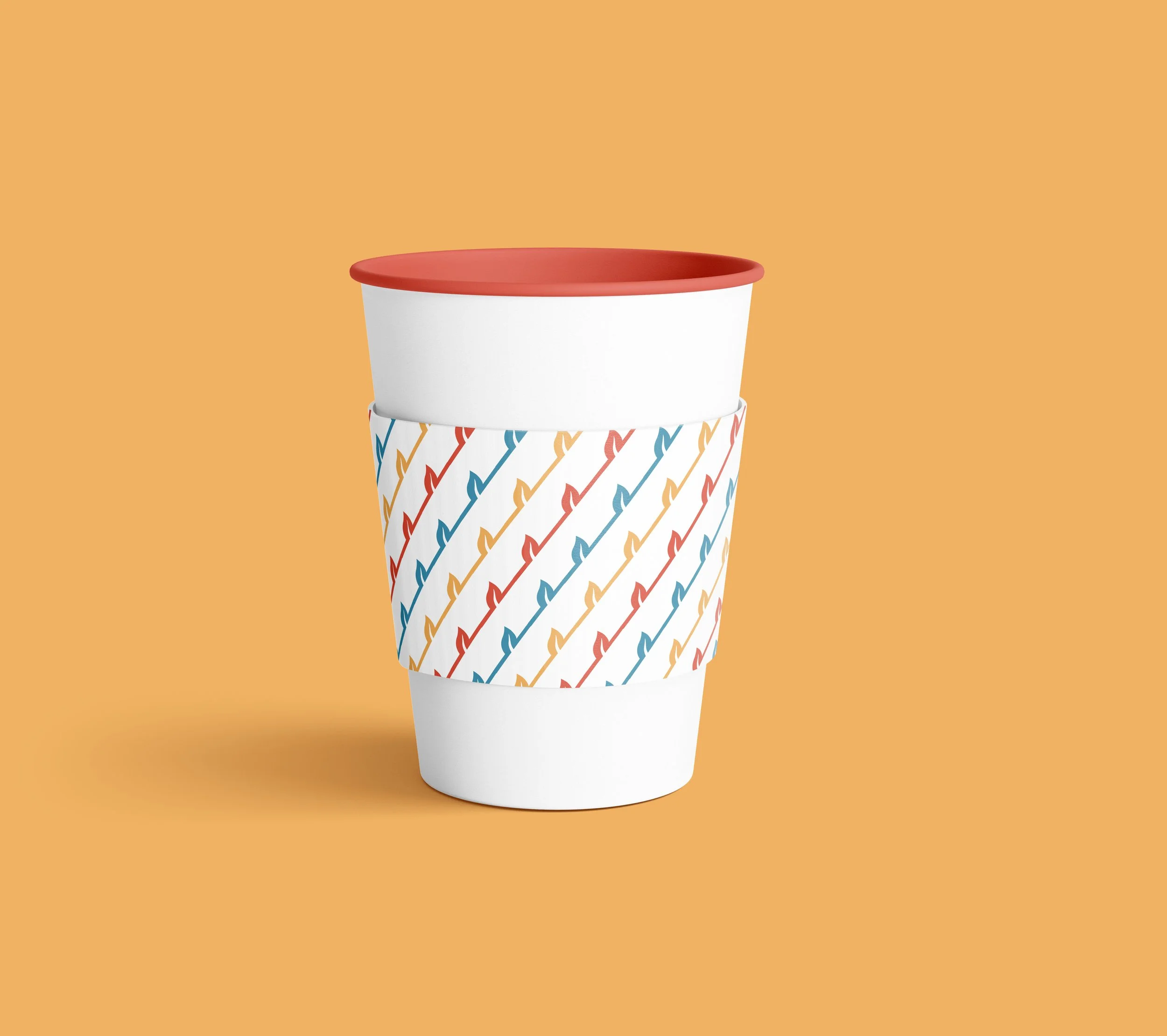 A white disposable coffee cup with a colorful, striped lightning bolt pattern wrapped around the middle, a white sleeve, and a red lid, set against an orange background.