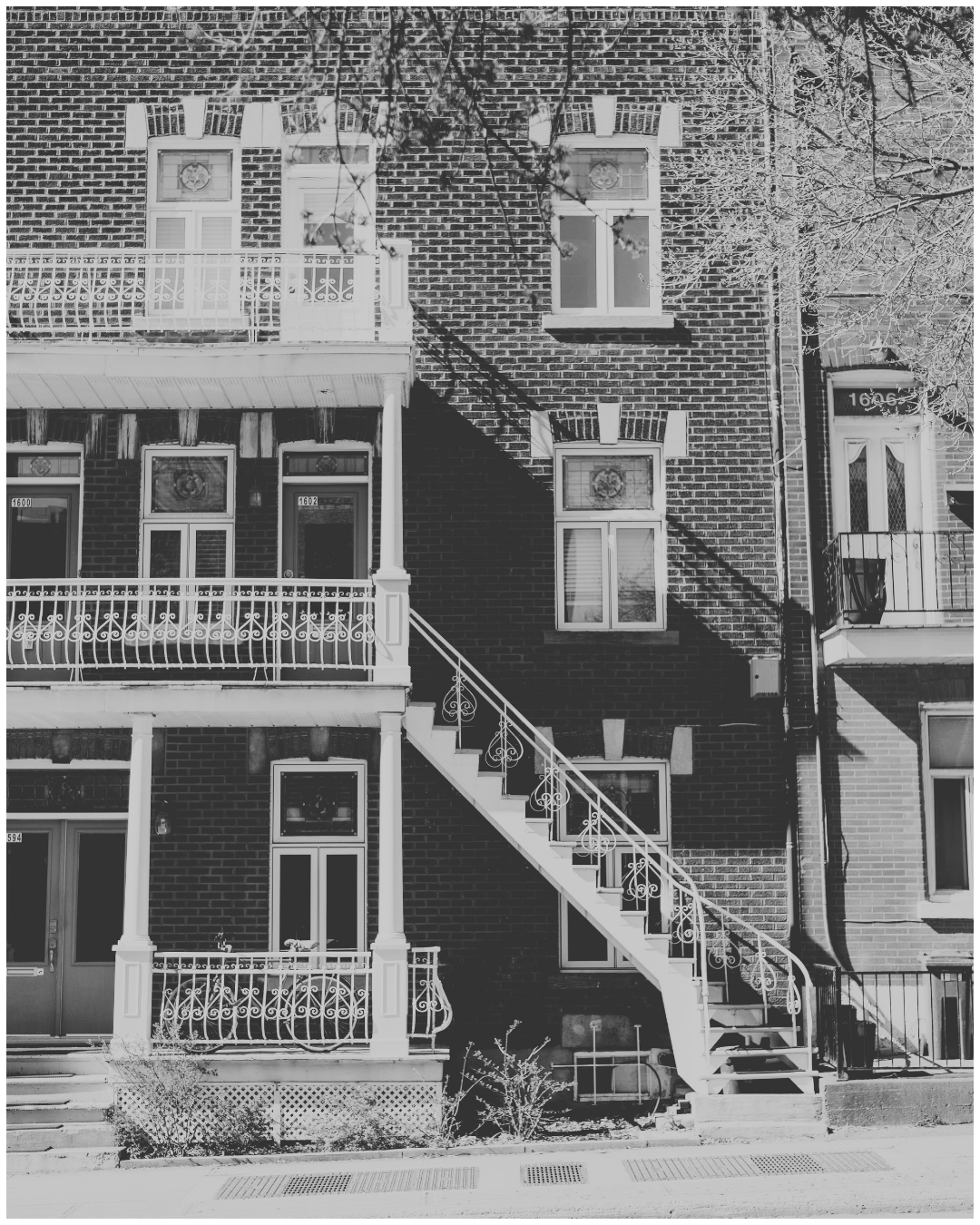Vue d'un triplex de Montréal à l'image de la réelle Maison Saint-Denis. Image en noir et blanc.