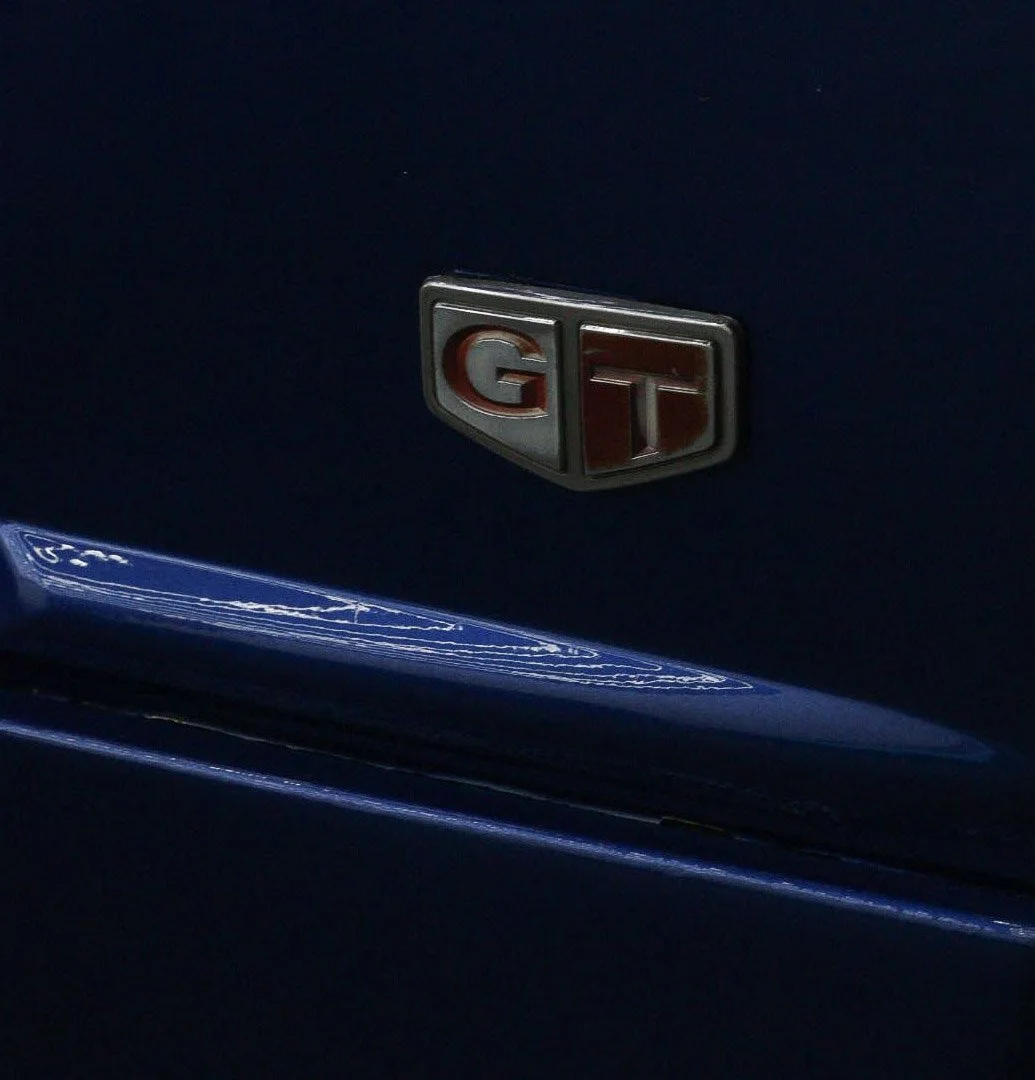 Close-up of a Toyota GTR badge on a dark blue car.