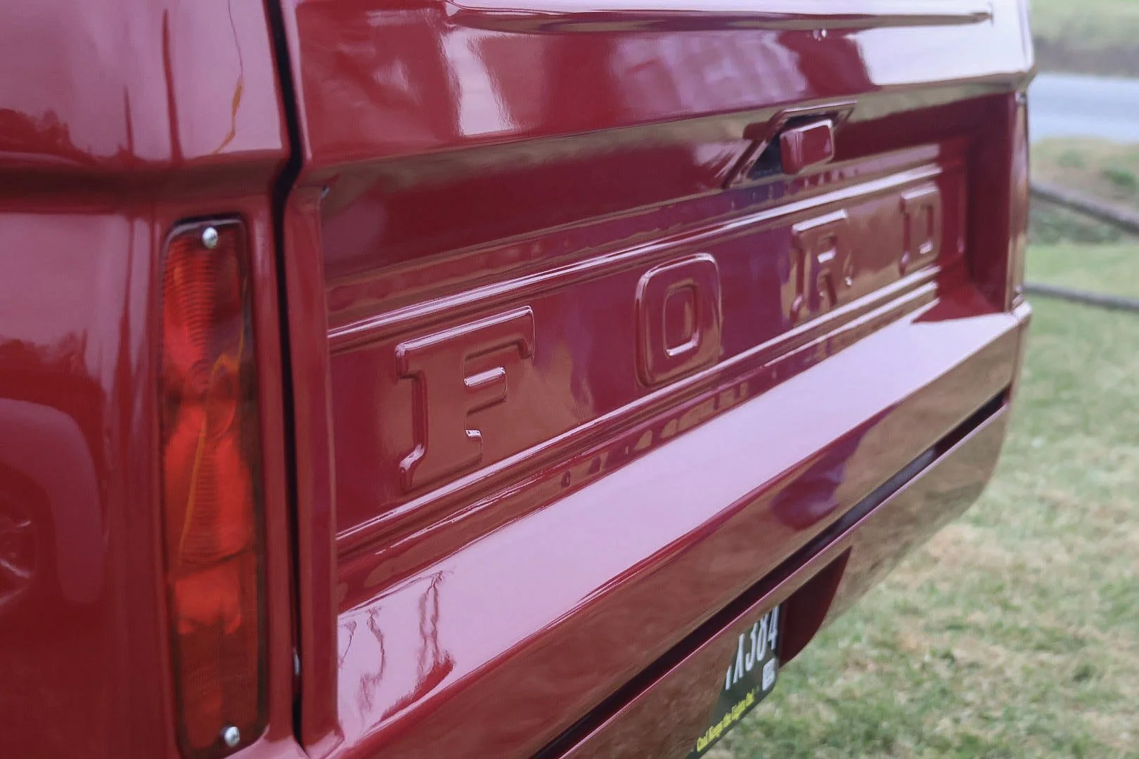 Close-up of a red Ford truck tailgate.