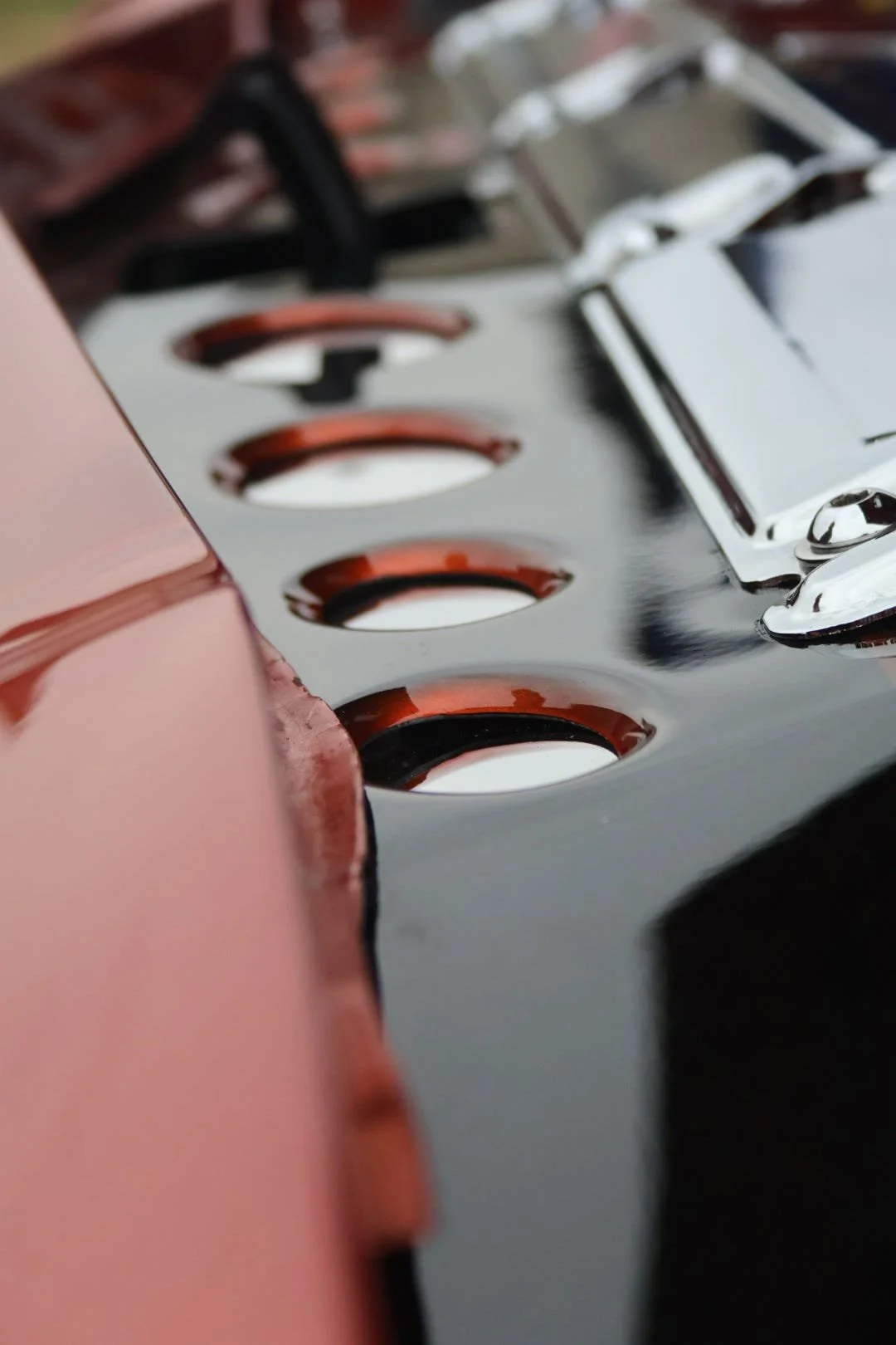 Close-up of a metallic keyboard with black and maroon keys, viewed at an angle.
