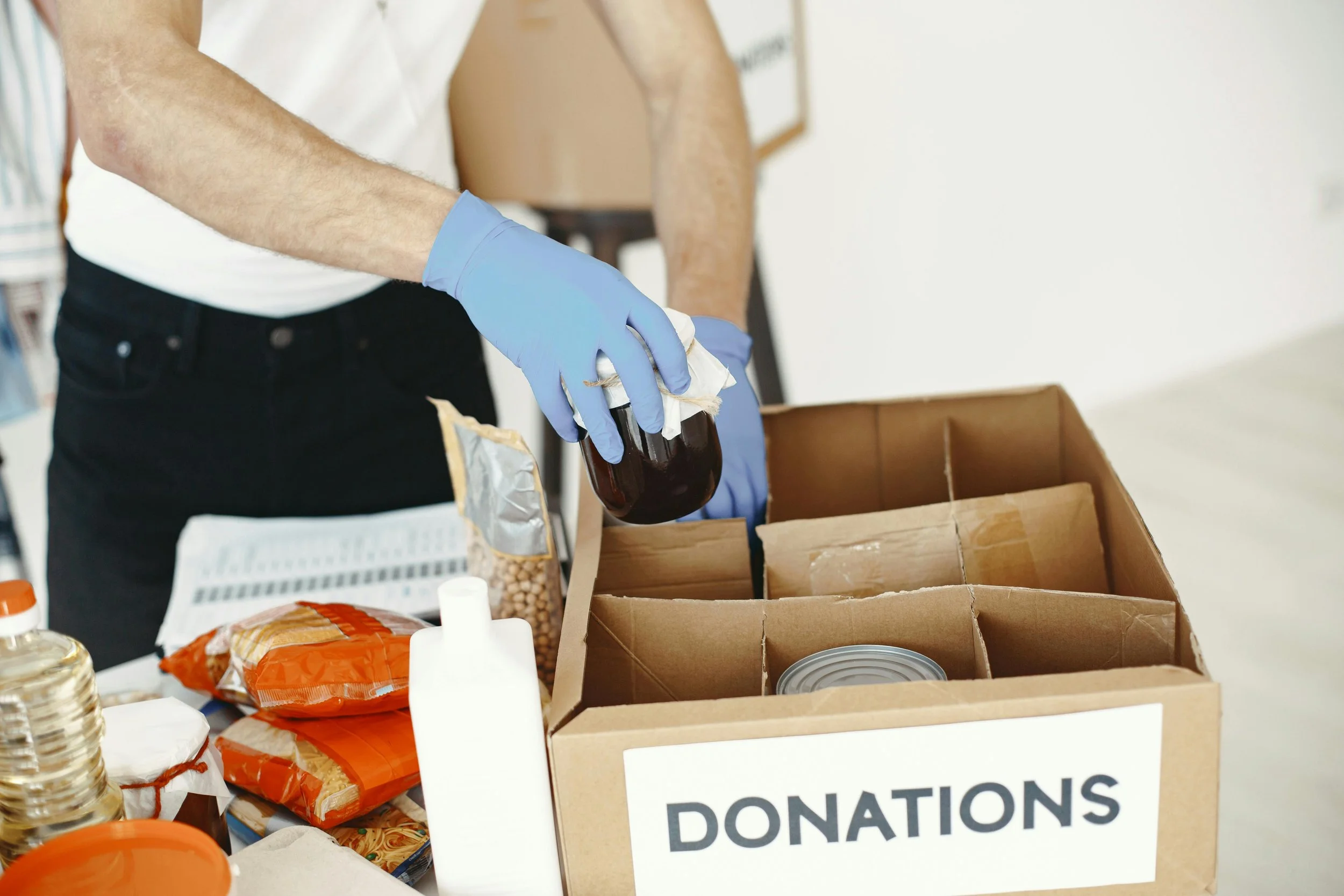 A volunteer loading non-perishables into a box at a food bank.