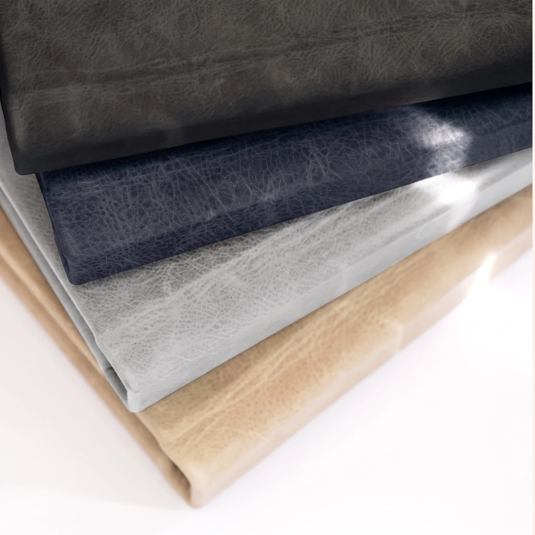 Stacked sheets of beige and brown textured paper or fabric, arranged diagonally.