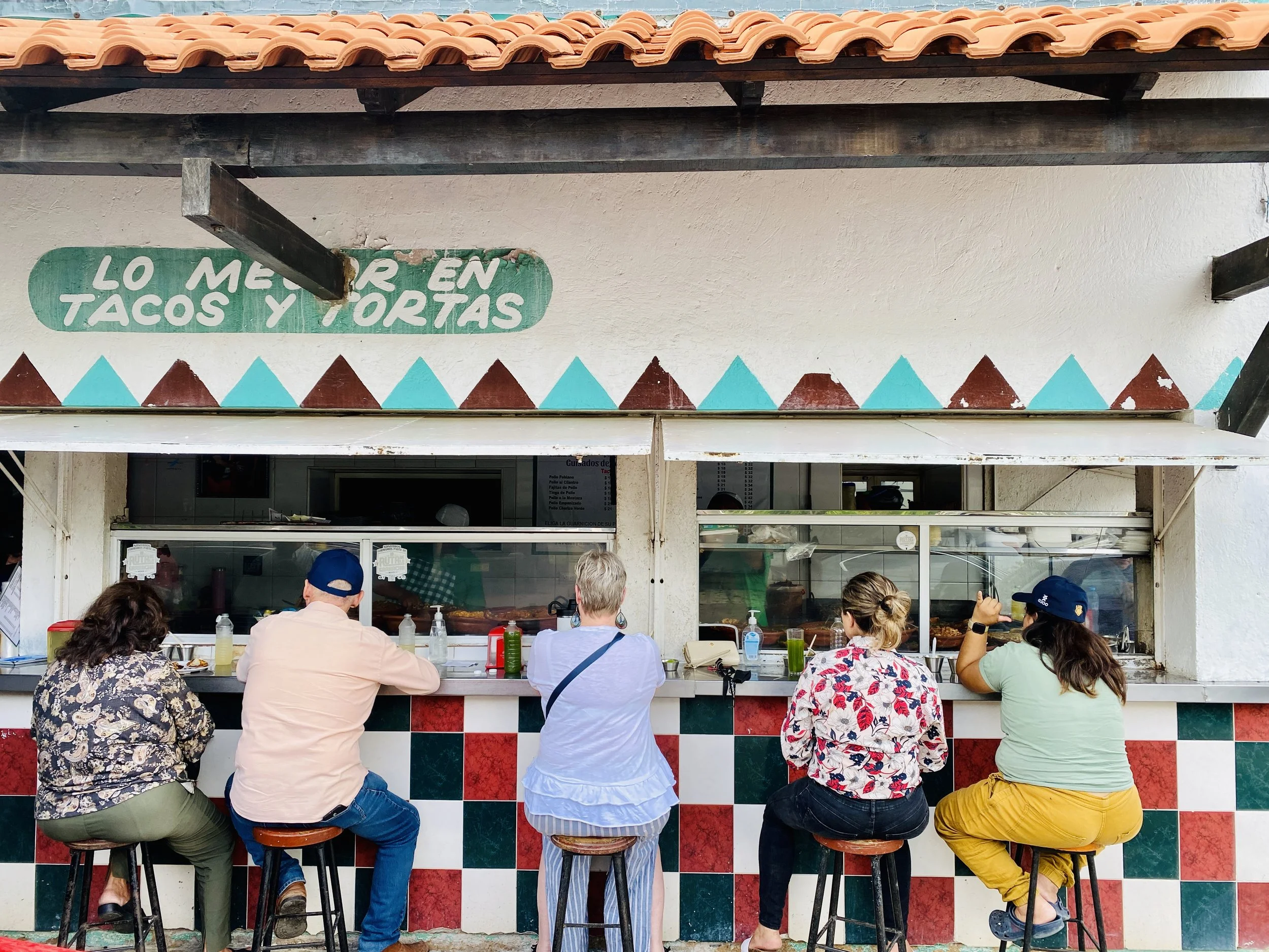 People eating tacos at the counter of Wayan’e taco stand in Itzimná, Mérida, Yucatán, Mexico