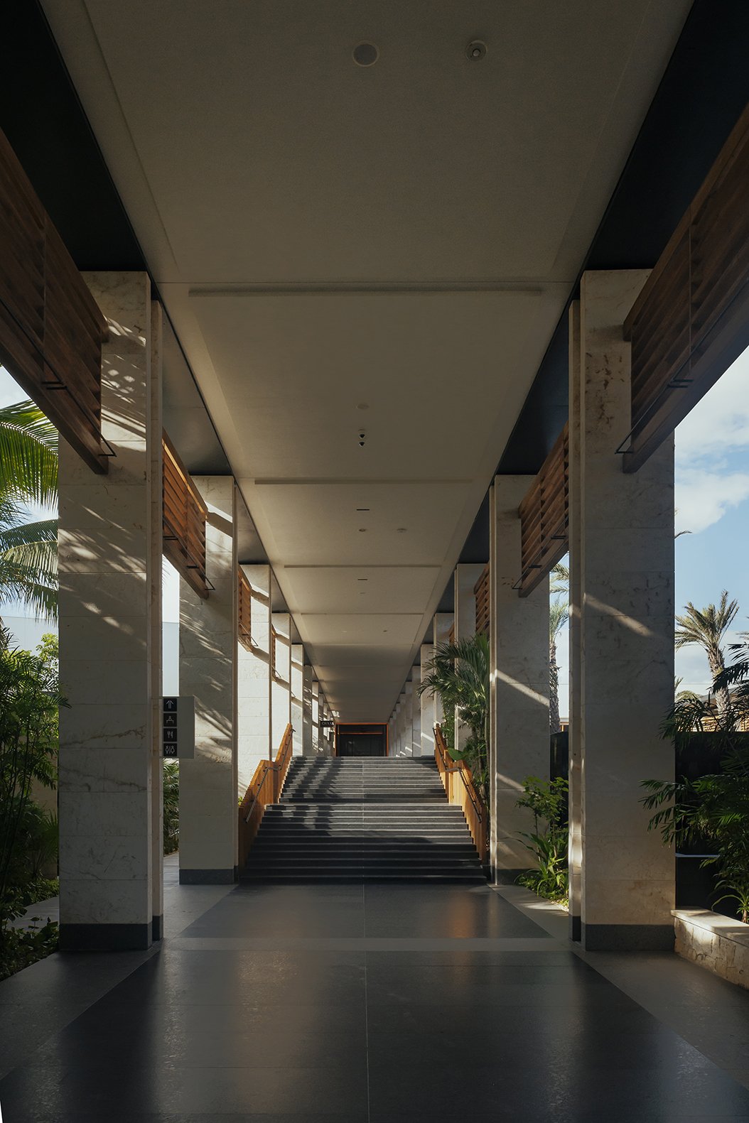 Simetría y claroscuro en pasillo arquitectónico tropical. Documentación de espacios. Voronoi Studio, México.