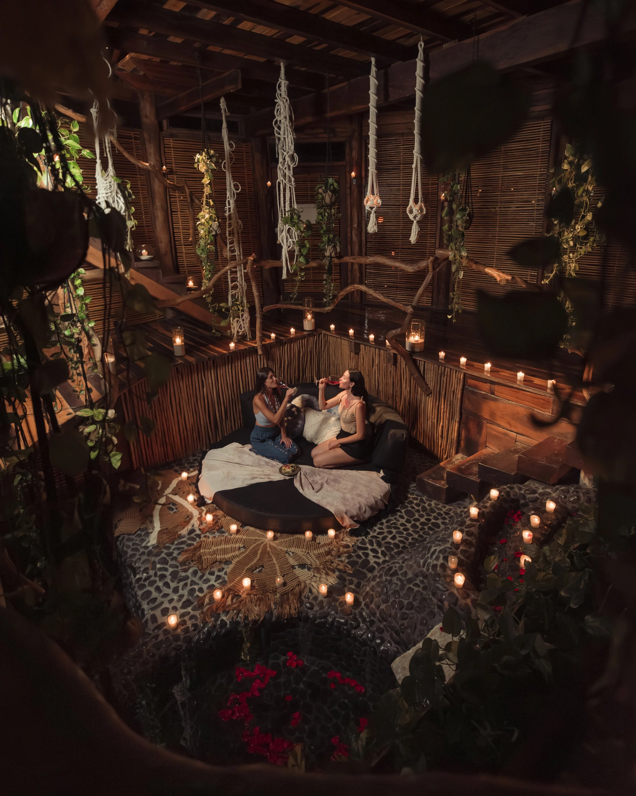 Luz de velas y claroscuro en nido tejido de madera. Diseño de experiencias de hospitalidad en Tulum.