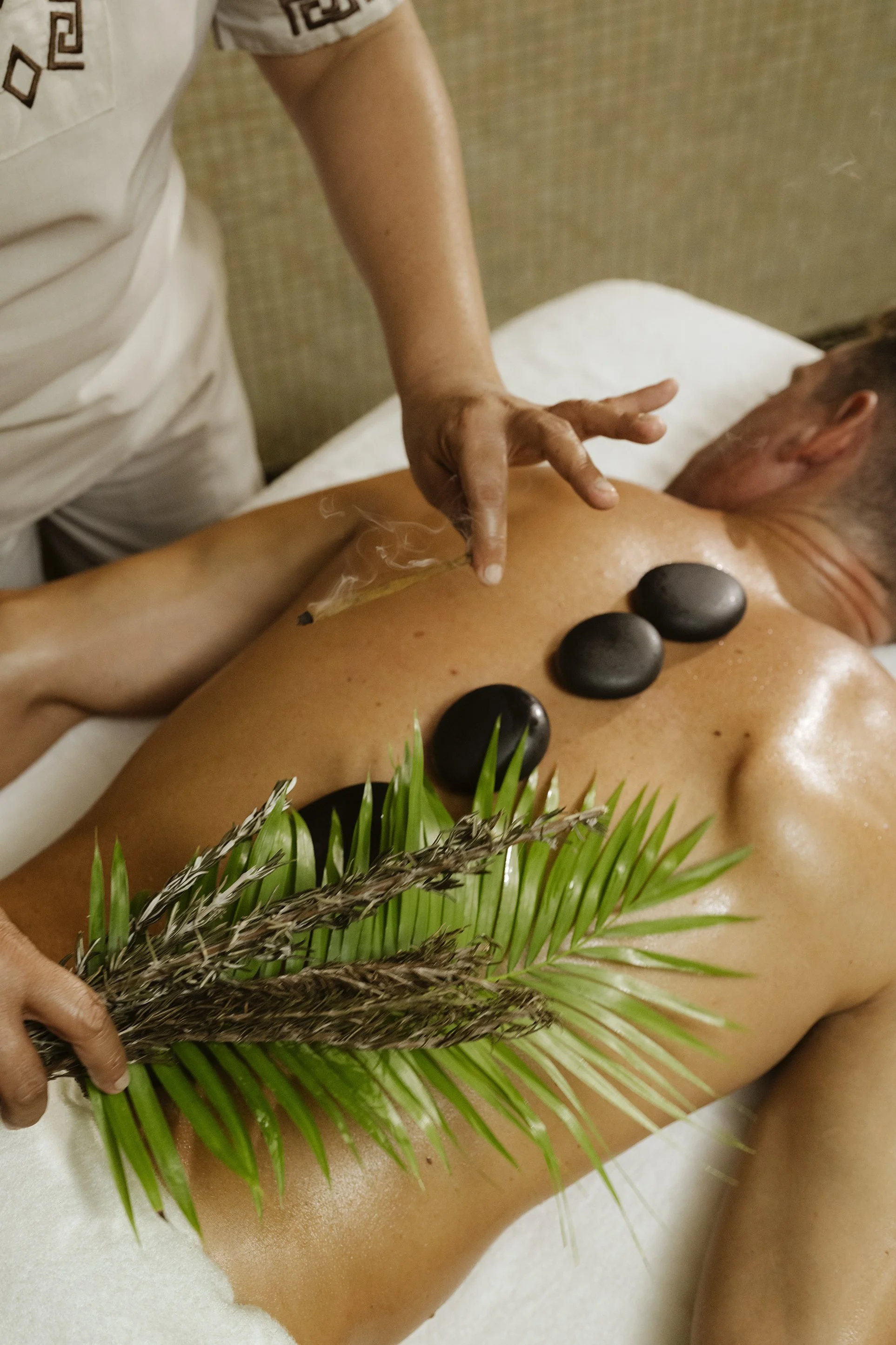 Masaje con piedras calientes y texturas orgánicas. Fotografía de hospitalidad y spa en Riviera Maya.
