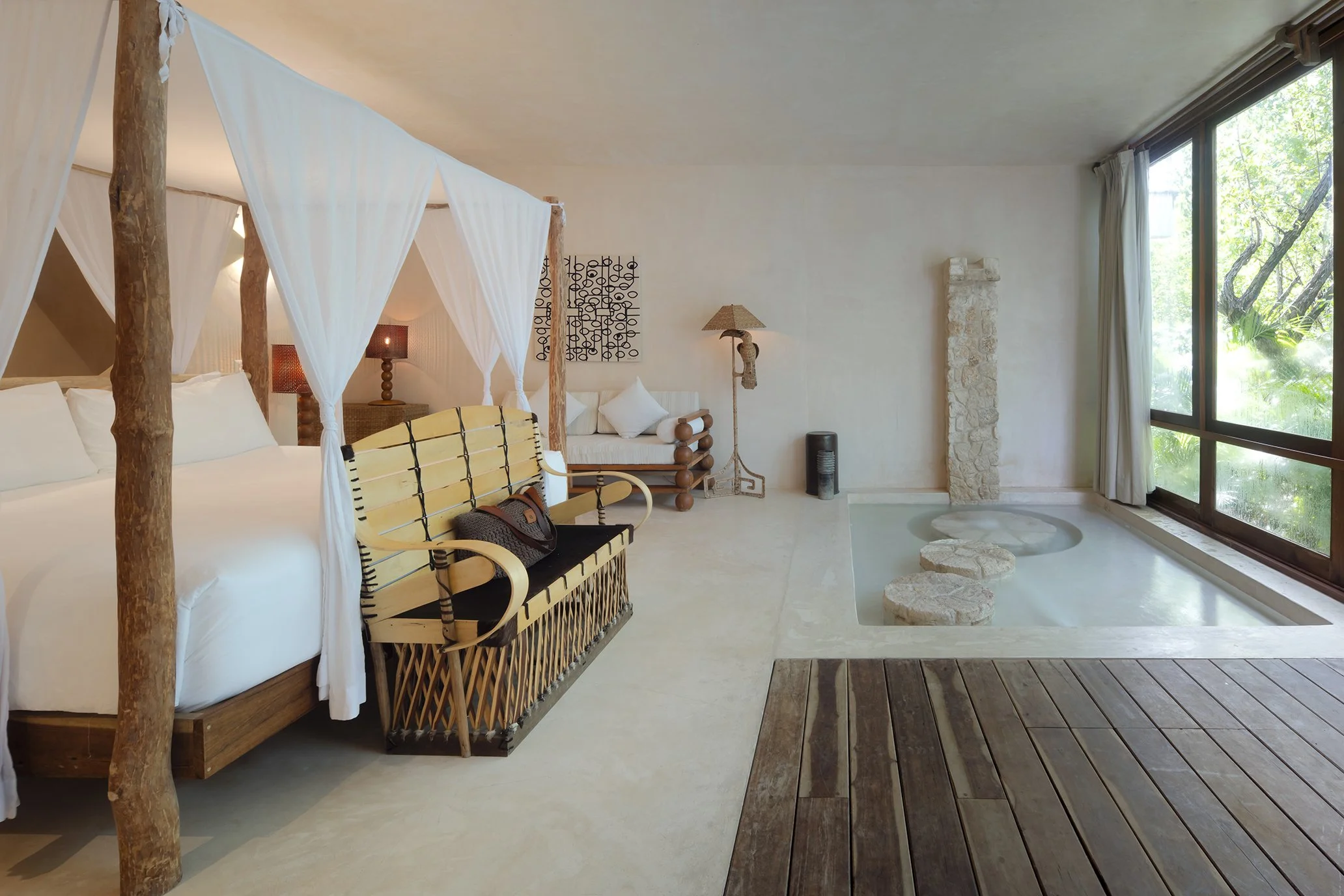 Interior minimalista con cama de dosel y texturas pétreas. Arquitectura de lujo en San José del Cabo.