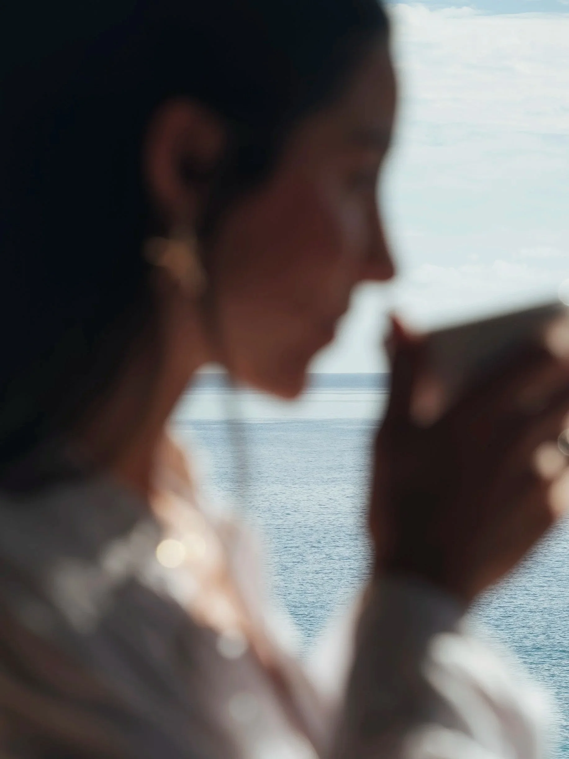 Silueta femenina y horizonte marino. Fotografía de hospitalidad y presencia atemporal por Voronoi Studio, México.