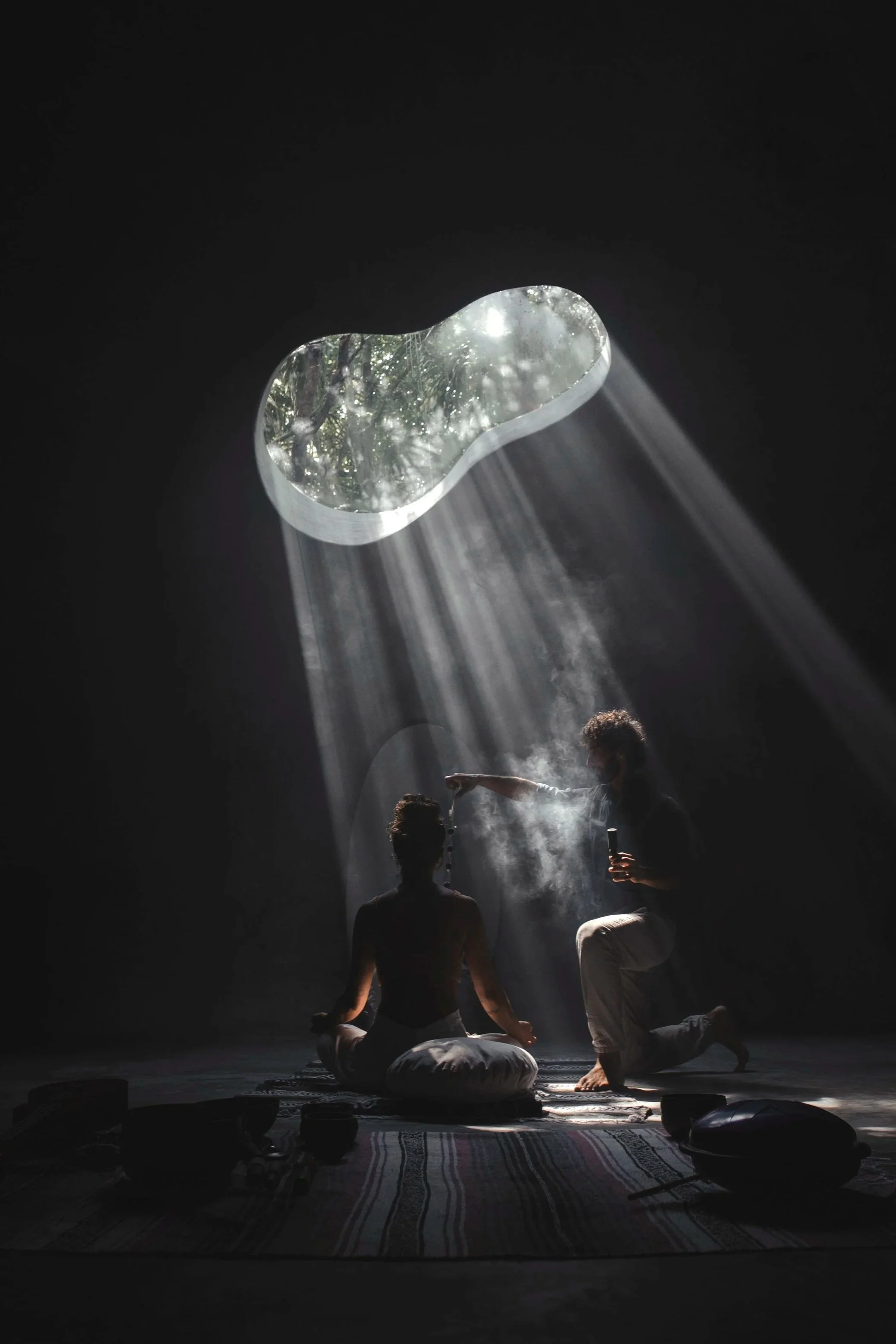 Claroscuro dramático y luz cenital sobre figura meditando en espacio orgánico. Arquitectura wellness en Tulum, México.