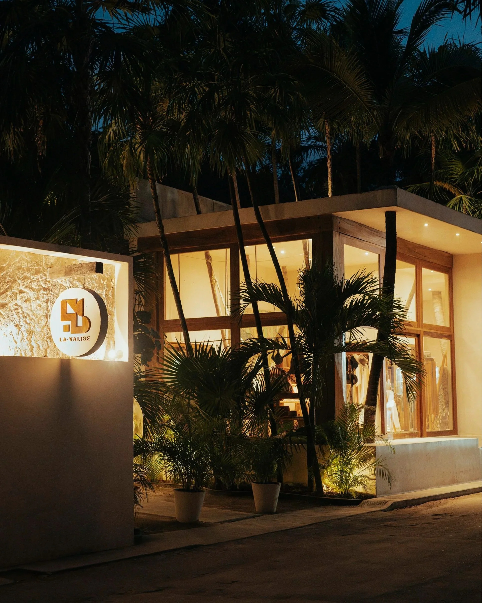 Fachada exterior iluminada del hotel La Valise en Tulum. Documentación arquitectónica nocturna.