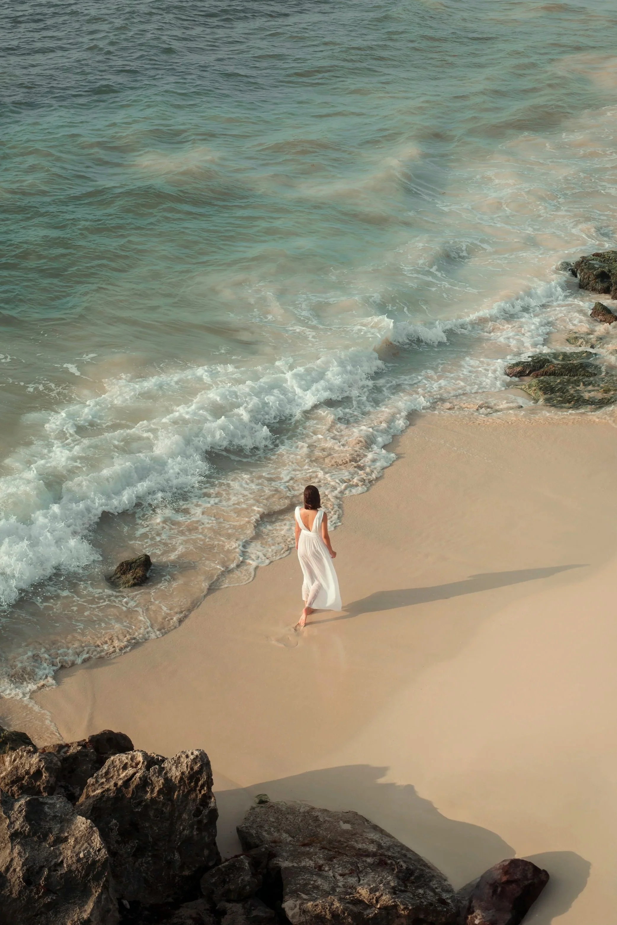 Vista aérea de mujer en playa. Storytelling visual y presencia atemporal en Tulum, México. Dirección Voronoi Studio.