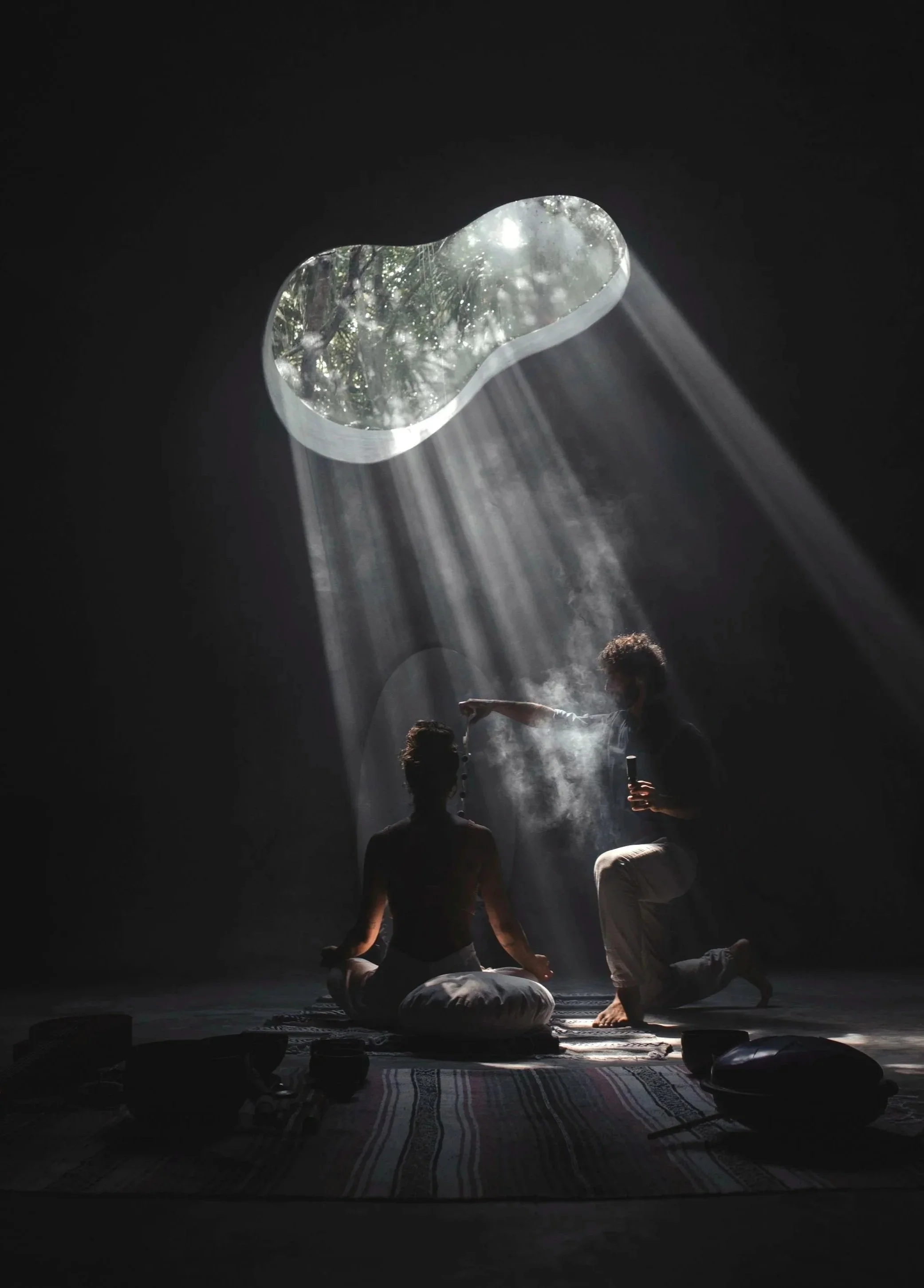 People practicing meditation in a dimly lit room with a skylight, rays of sunlight shining through, creating a serene atmosphere.