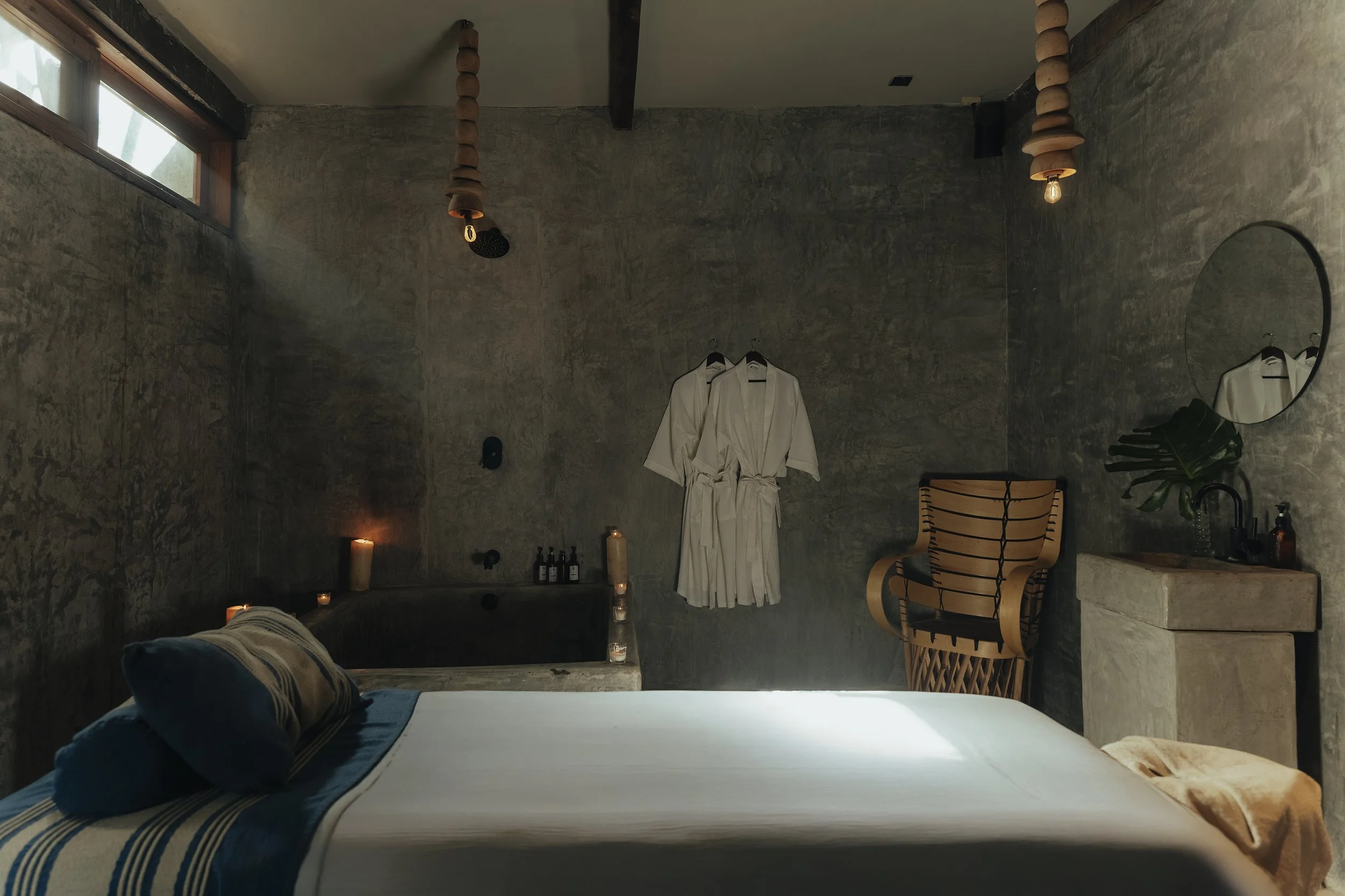Claroscuro dramático en cabina de spa con muros de concreto. Documentación de espacios en Tulum.