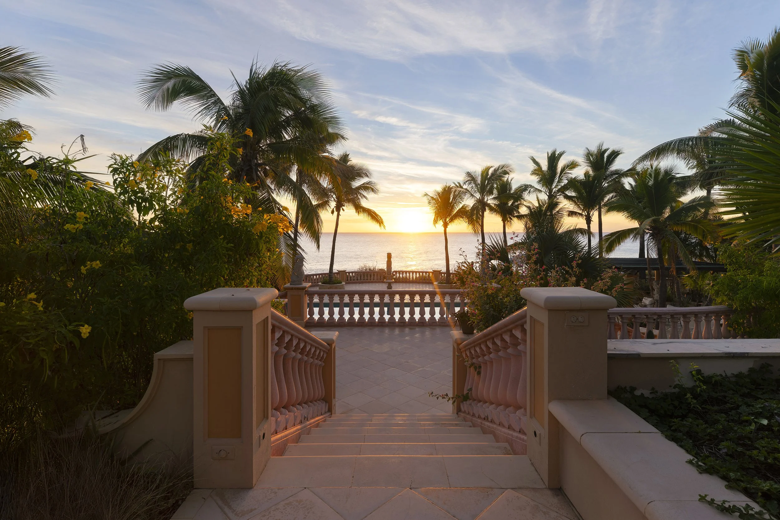 Simetría de exterior al atardecer con palmeras. Fotografía de hospitalidad de lujo en Cabo San Lucas. Voronoi Studio.
