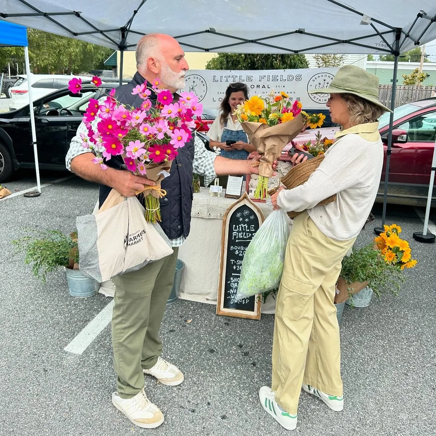Neighbors collecting their weekly flowers from Little Fields Floral at the St. Michael's Farmers Market.