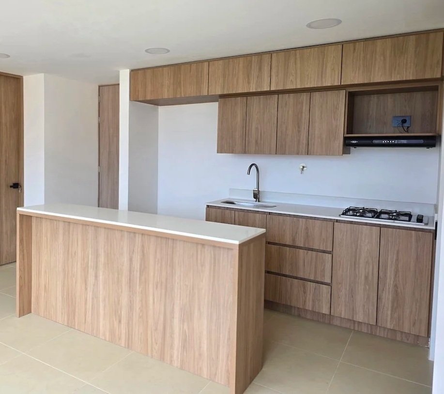Cocina moderna con gabinetes de madera, encimera blanca, fregadero y estufa.