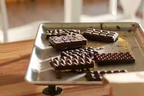 Various types of chocolate bars on a ceramic dish.