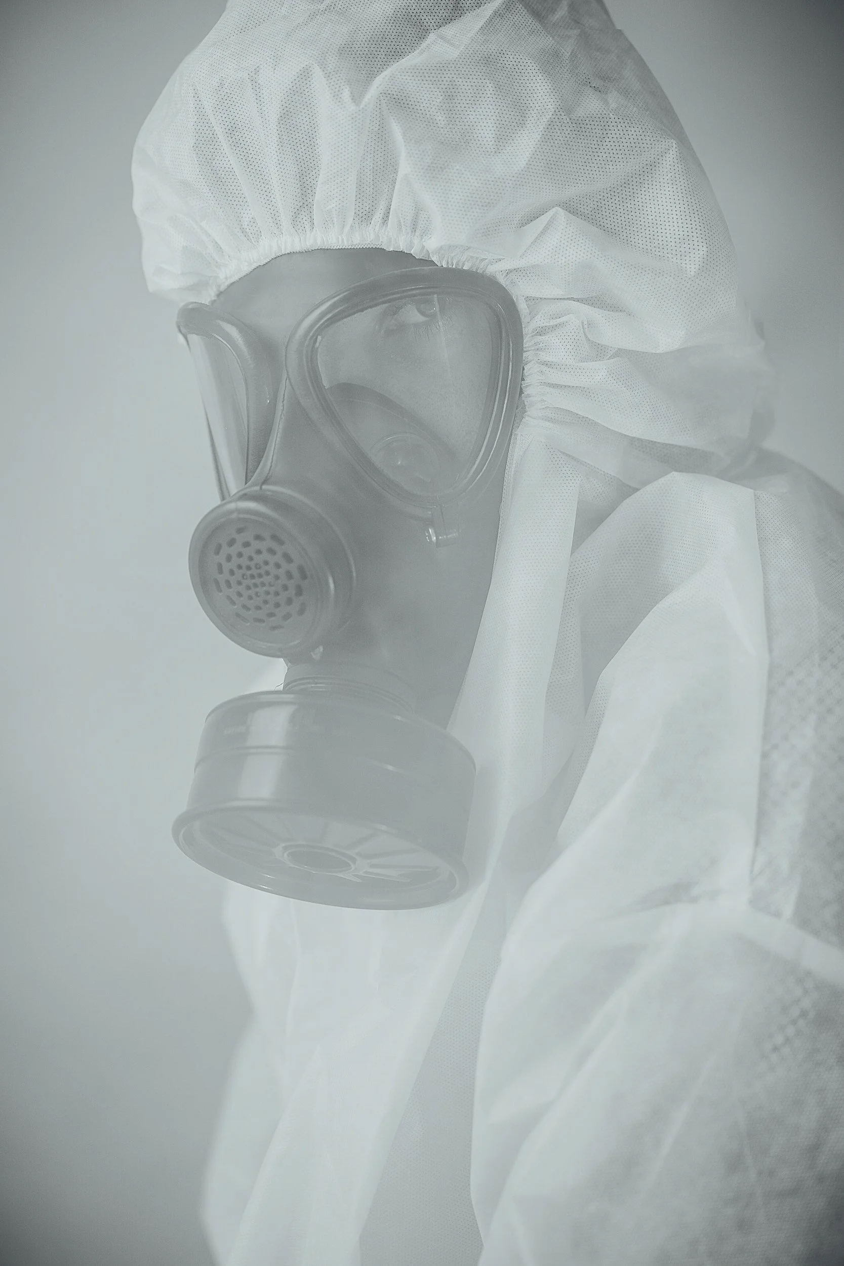 Asbestos inspector wearing a respirator and a full-body protective coveralls.