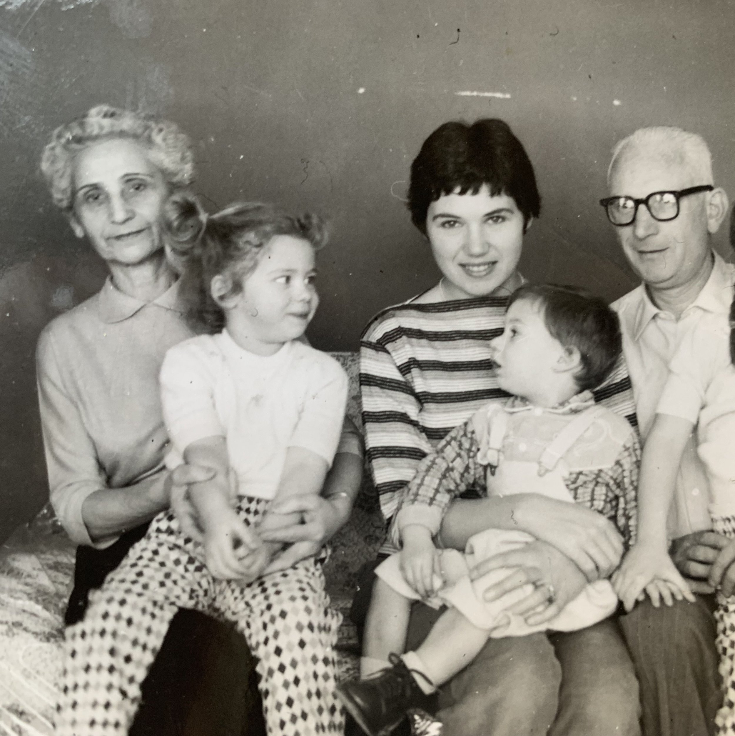 Black and white photo of a family group, including women and children, gathered together and smiling at the camera.