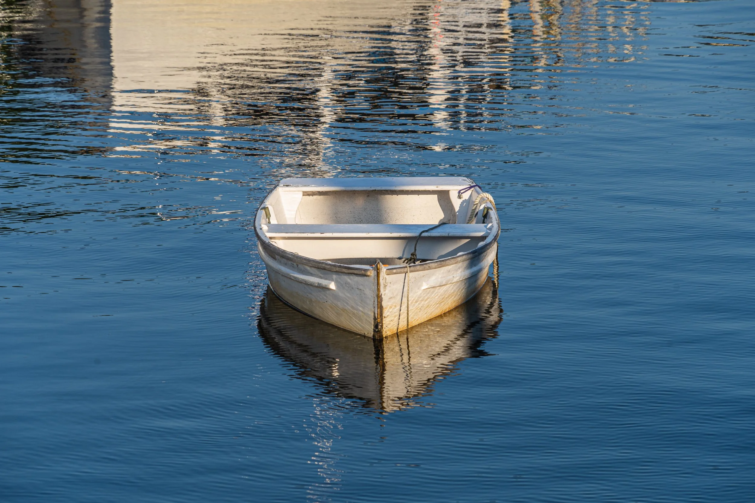 Small rowboat floating in the calm waters of Perkins Cove