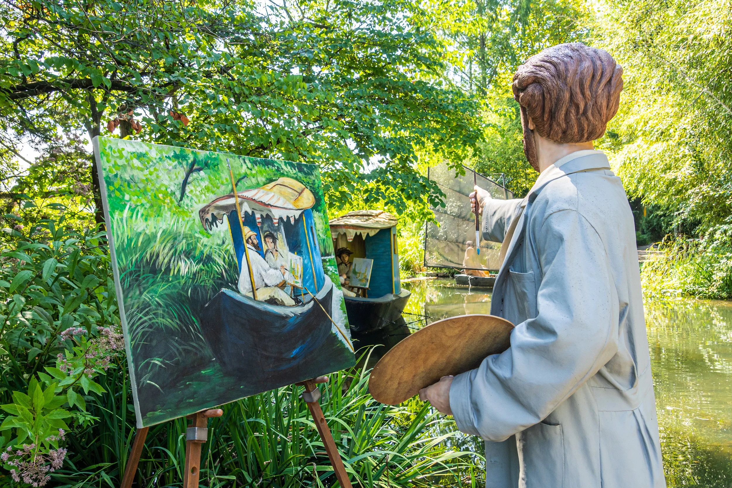 Sculpture of Claude Monet painting his floating studio boat beside a pond at Grounds For Sculpture in Hamilton, New Jersey.