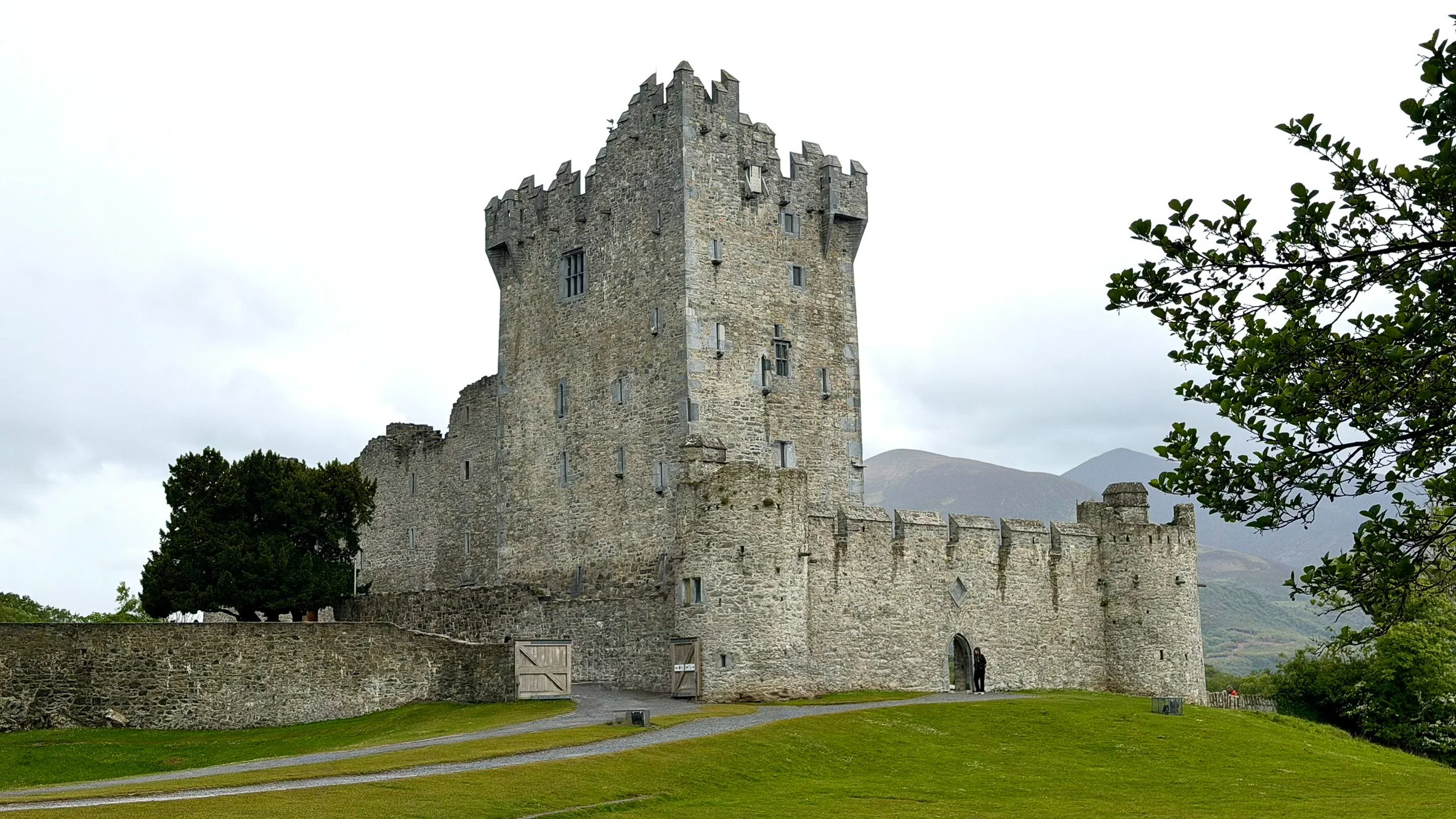 Ross Castle stands along the shores of Lough Leane in Killarney National Park, with the mountains of County Kerry rising behind the medieval fortress.