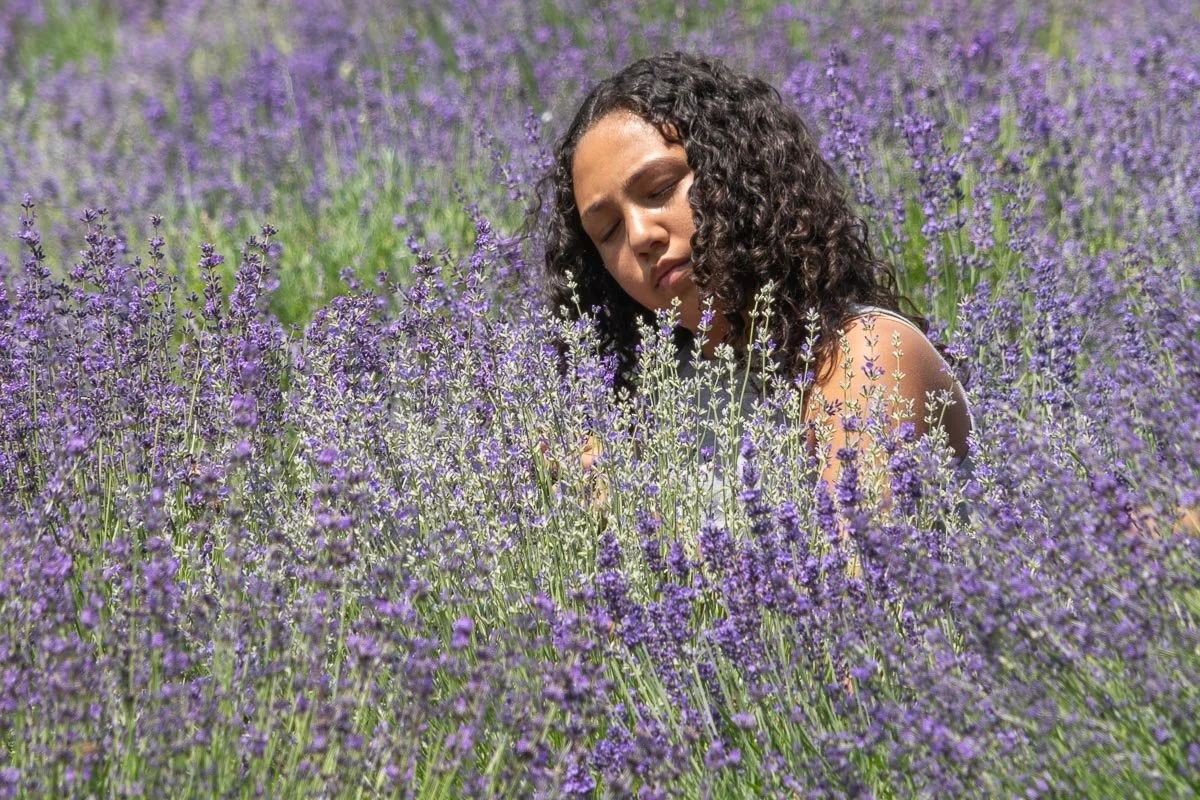 Visitor with eyes closed surrounded by blooming lavender at Peace Valley Lavender Farm in Bucks County, Pennsylvania.
