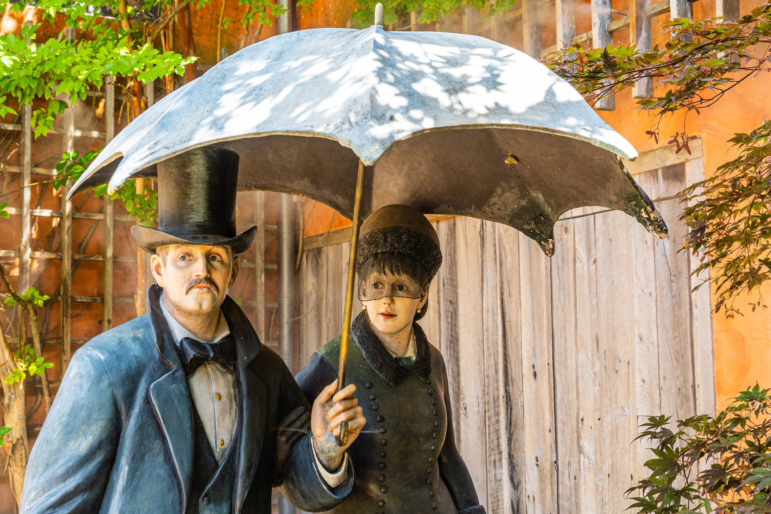 Life-size sculptures inspired by an Impressionist couple walking beneath a parasol at Grounds For Sculpture in Hamilton, New Jersey.