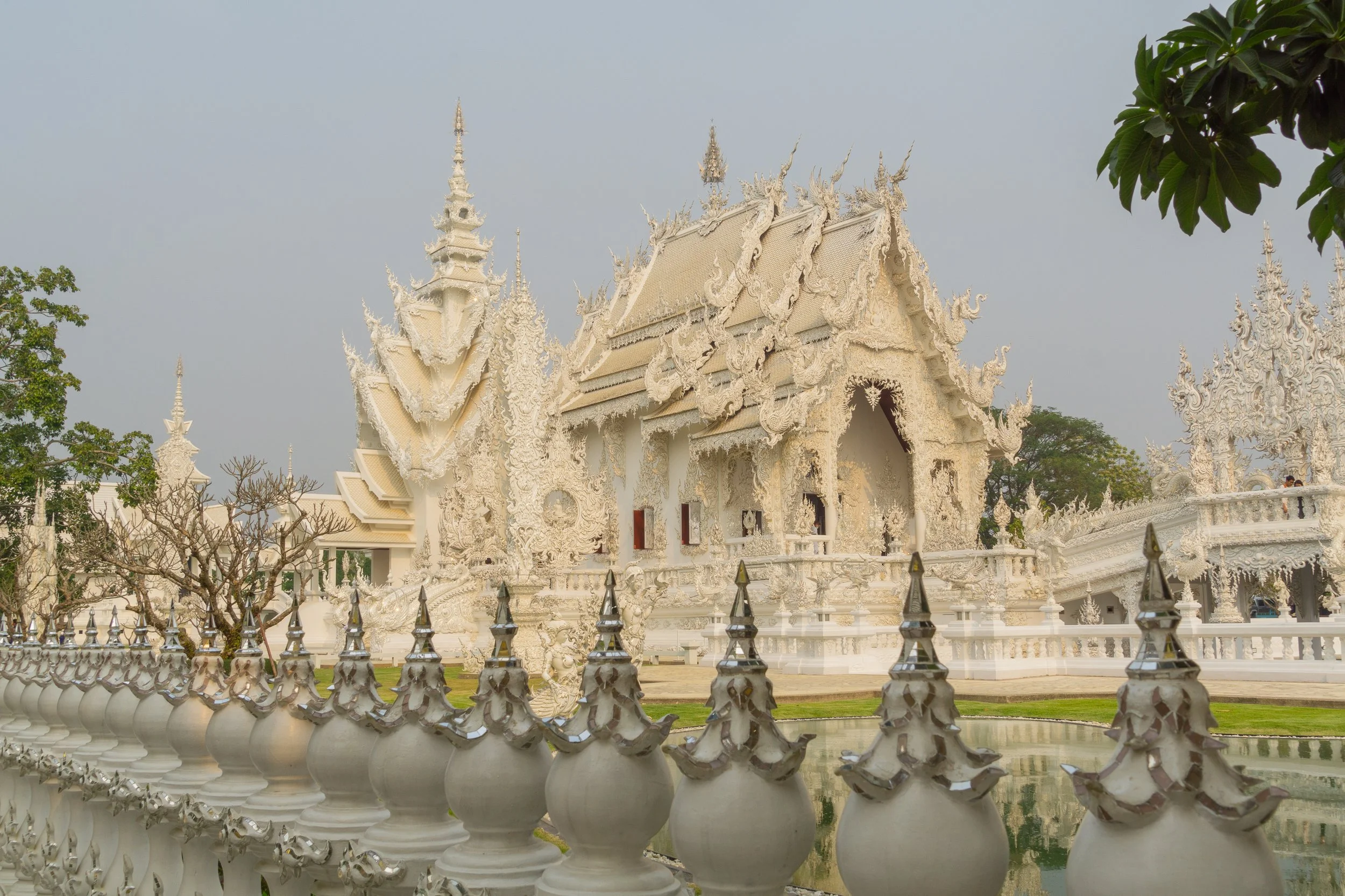 The ornate white exterior of Wat Rong Khun (White Temple) in Chiang Rai, Thailand.