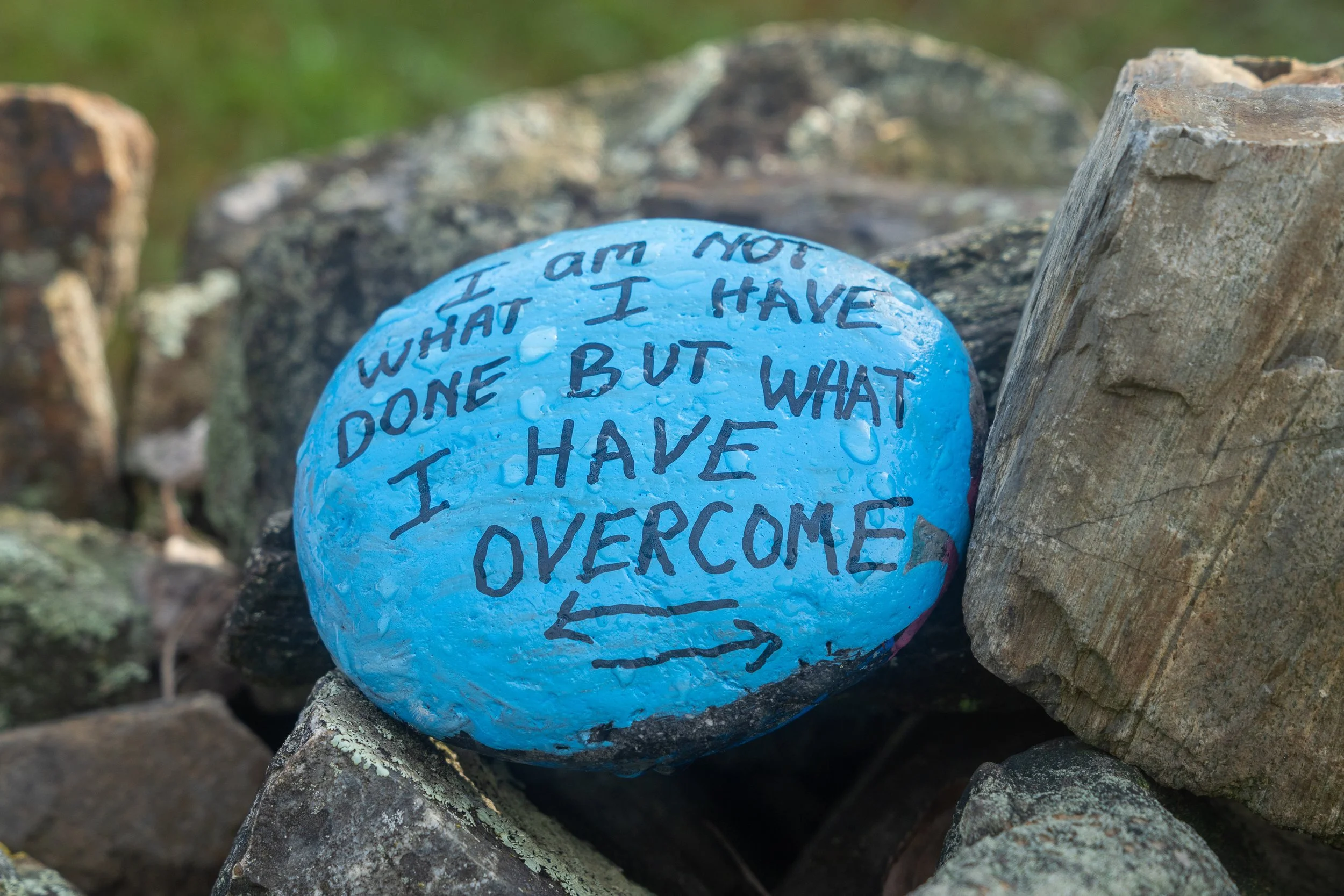 Painted stone reading, "You are more than what you have done, but what you have overcome."