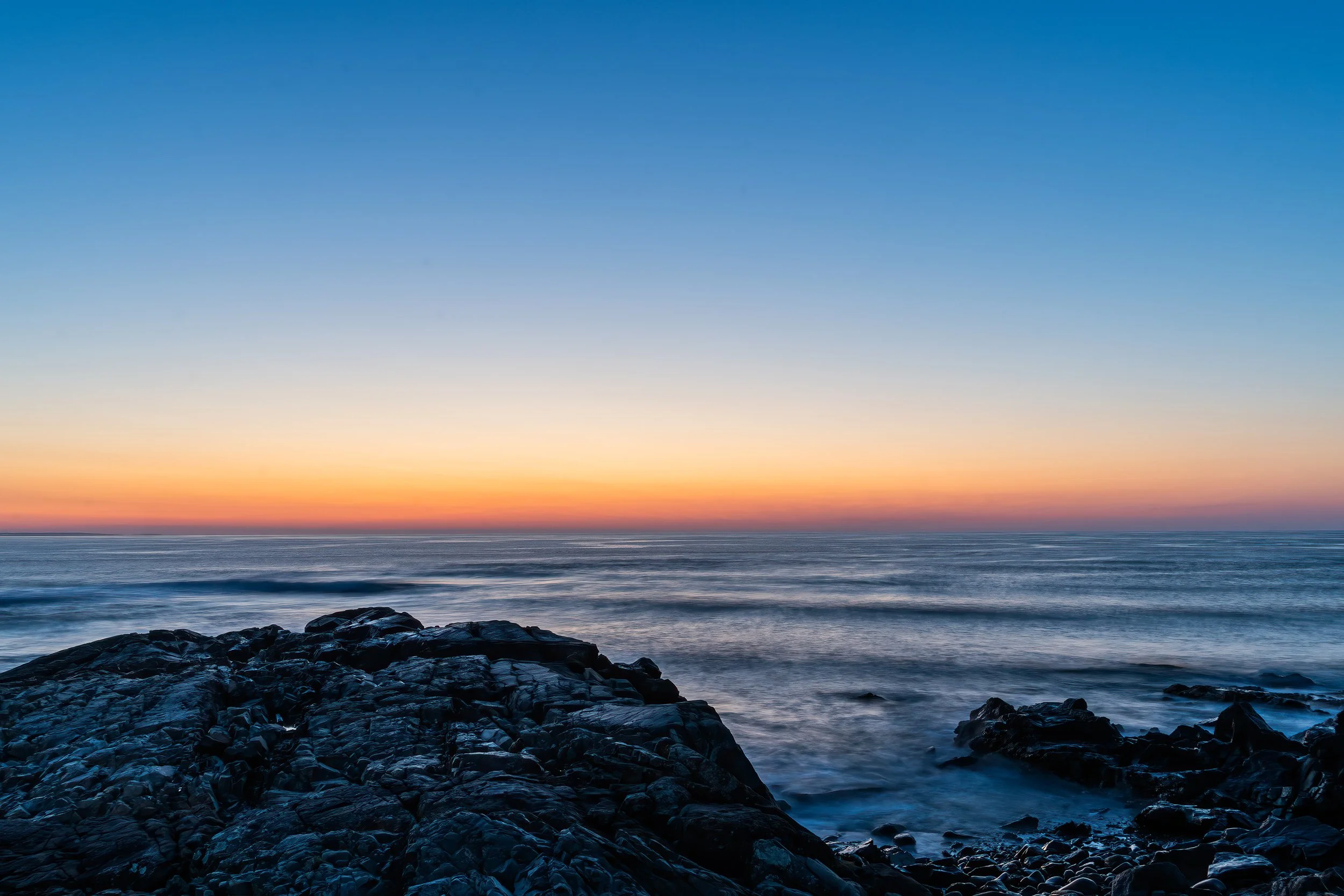 Rocky coastline overlooking the Atlantic Ocean before sunrise in Ogunquit, Maine