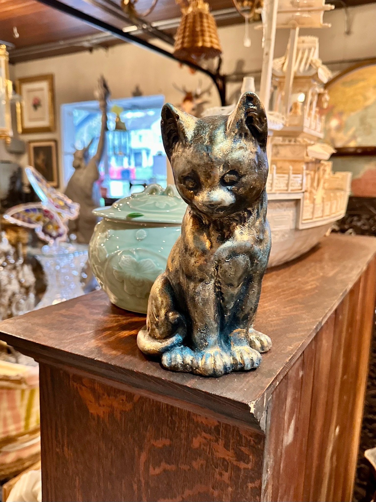 Handmade in Connecticut cat figure for sale at Villa Vintiques. A decorative ceramic cat figurine sitting on a wooden shelf.