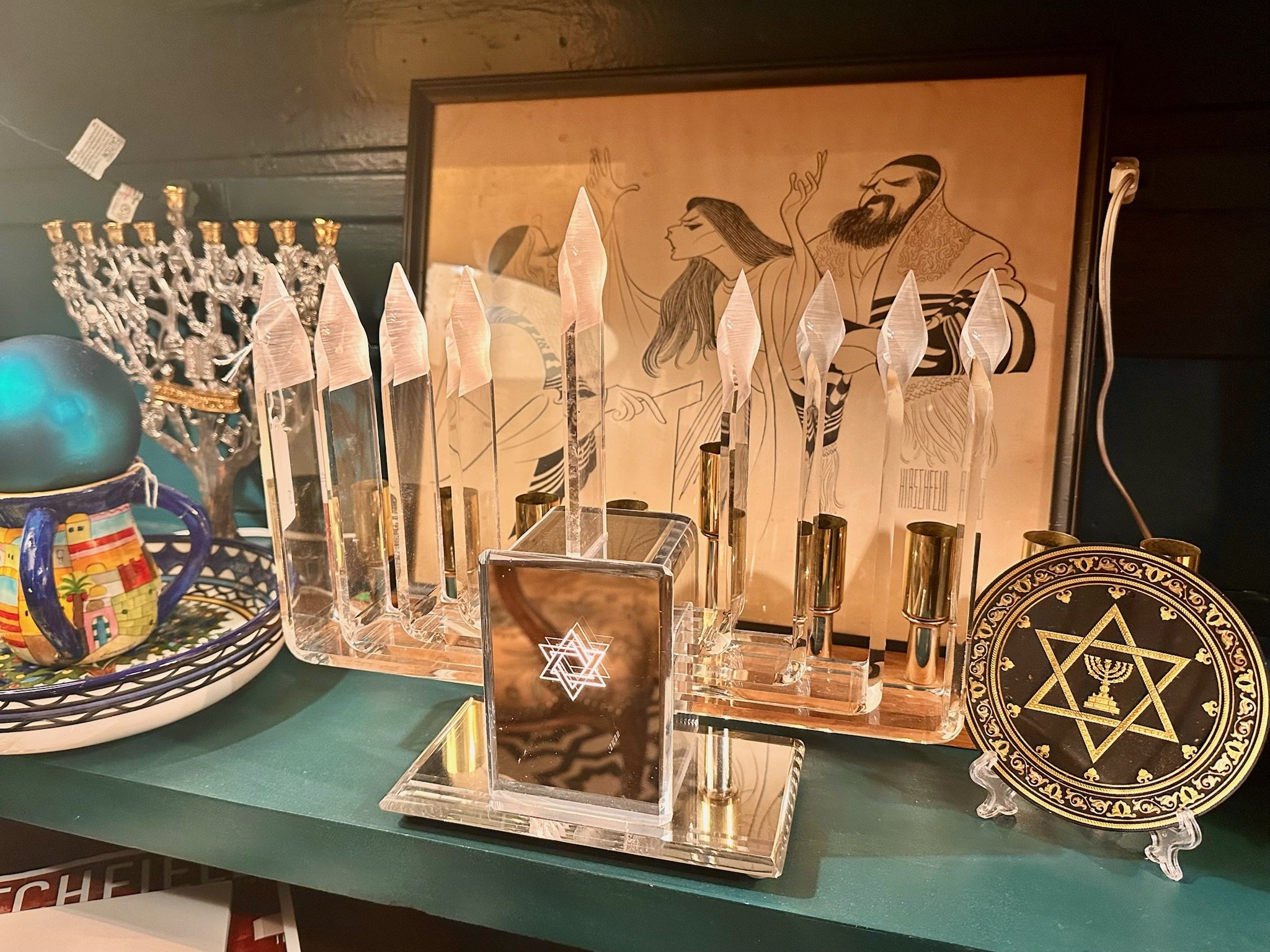 Inside Villa Vintiques, decorative items including clear acrylic vintage menorah with a Star of David design