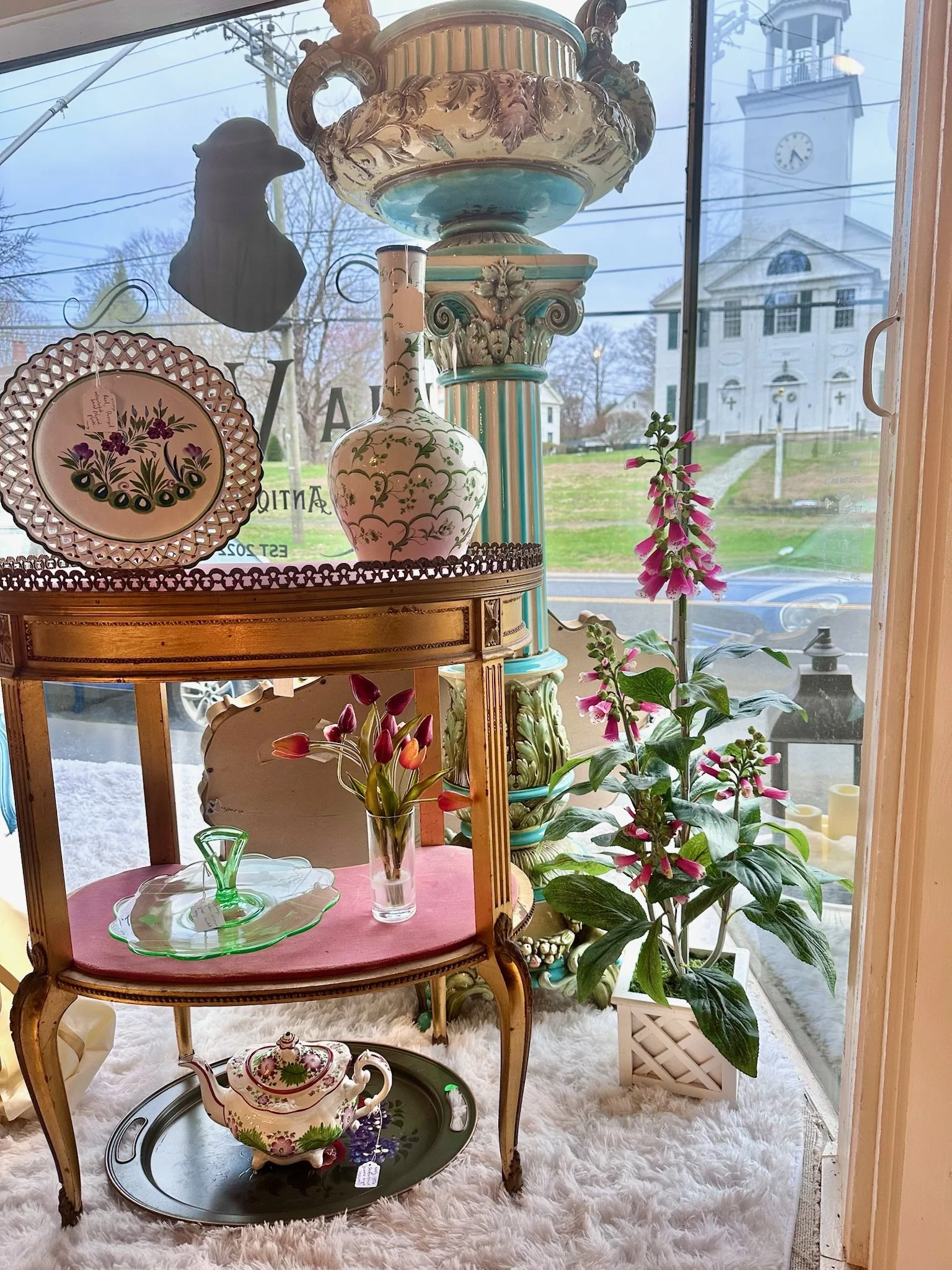 Spring display window at VIlla Vintiques from inside, looking out with the North Congregational Church in the background.