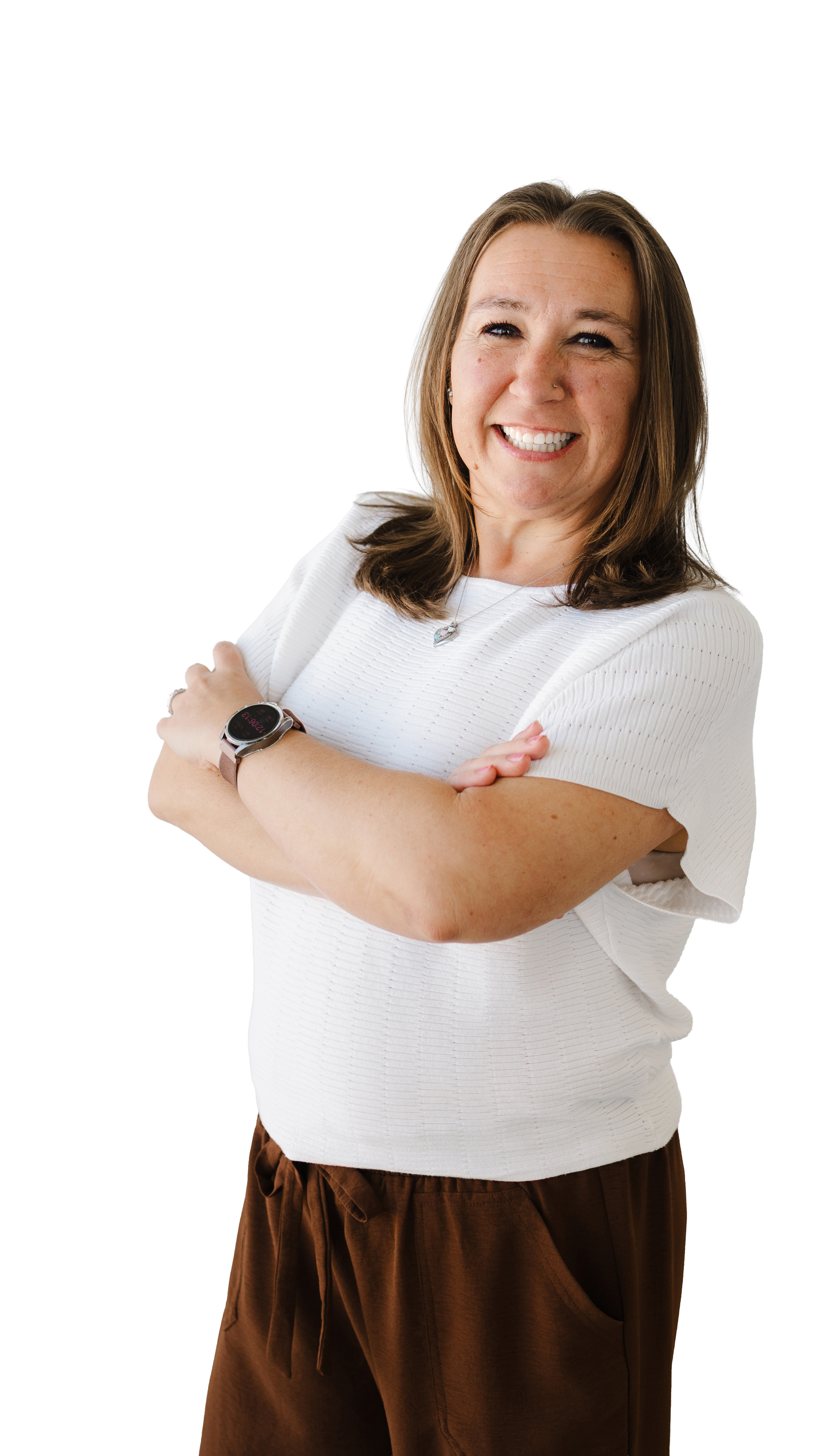Becky Brown | A woman smiling, with arms crossed, wearing a white top, brown pants, and a watch.