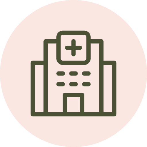 Line drawing icon of a hospital building with a cross symbol at the top center, on a light pink circular background.